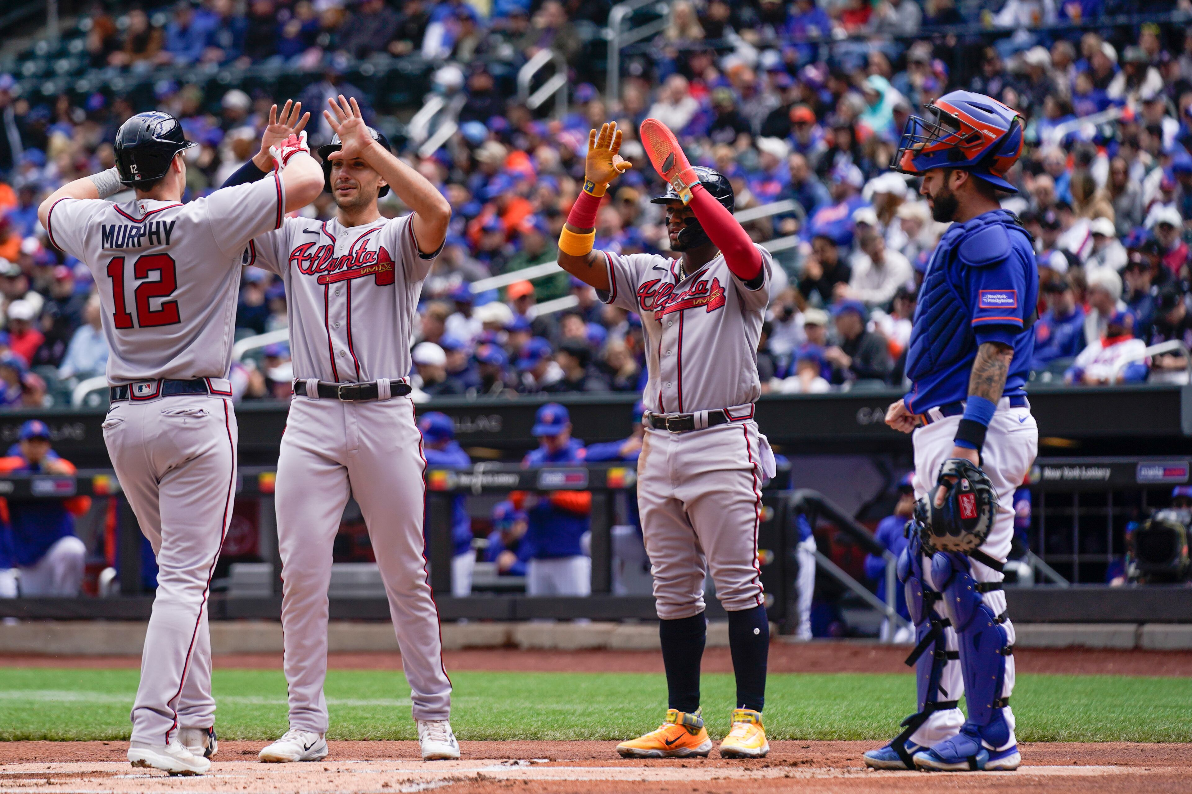 New York Mets catcher Tomas Nido watches as Sean Murphy (12) is greeted by Braves teammates Matt Olson, second from left, and Ronald Acuna Jr. after hitting a three-run home run during the first inning of the first game of a baseball doubleheader at Citi Field, Monday, May 1, 2023, in New York.