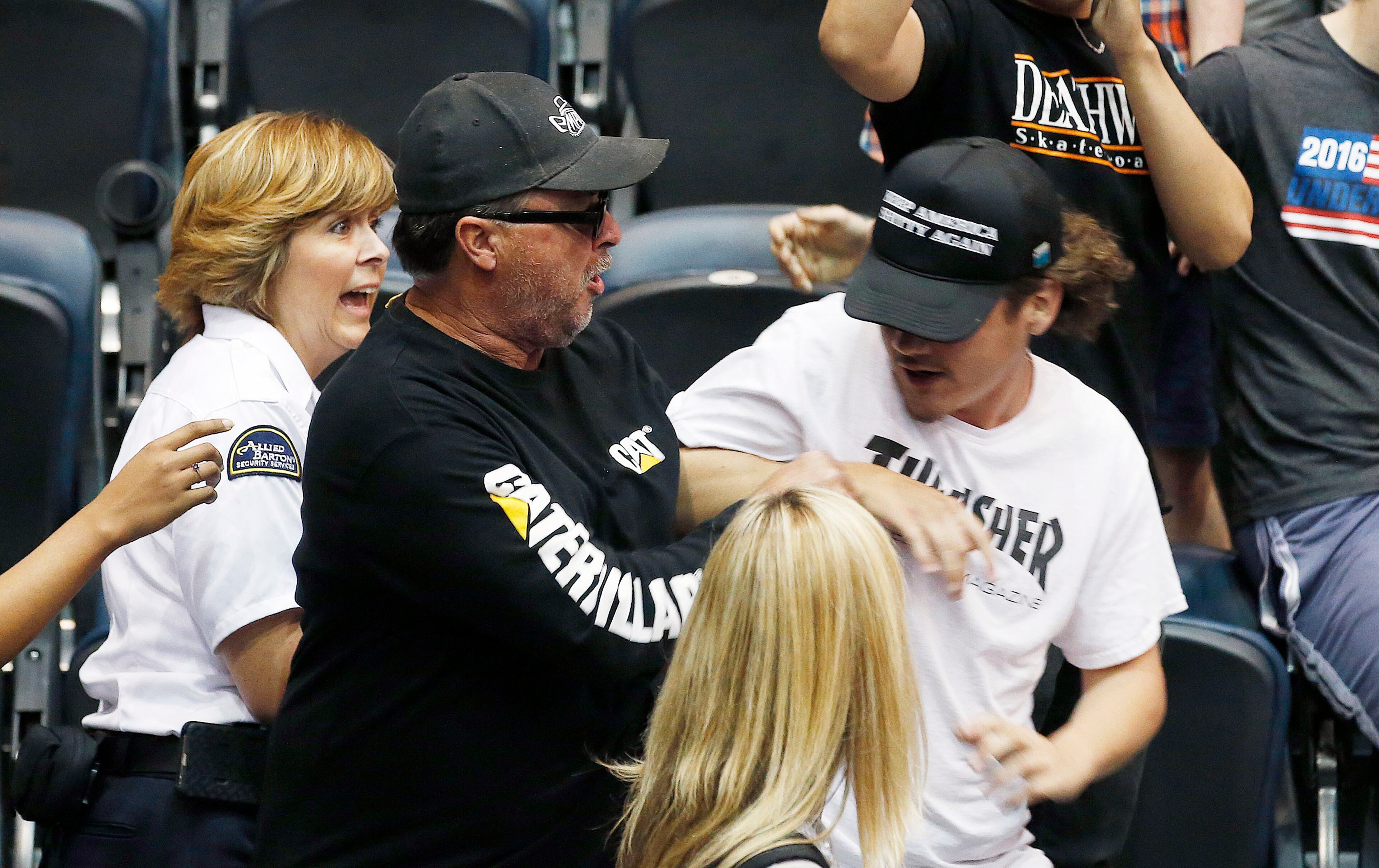A supporter of Republican presidential candidate Donald Trump, middle, scuffles with a protester, right, as the protester is escorted out of the venue by security as the Republican presidential candidate speaks during a campaign rally Saturday, March 19, 2016, in Tucson, Ariz. (AP Photo/Ross D. Franklin)