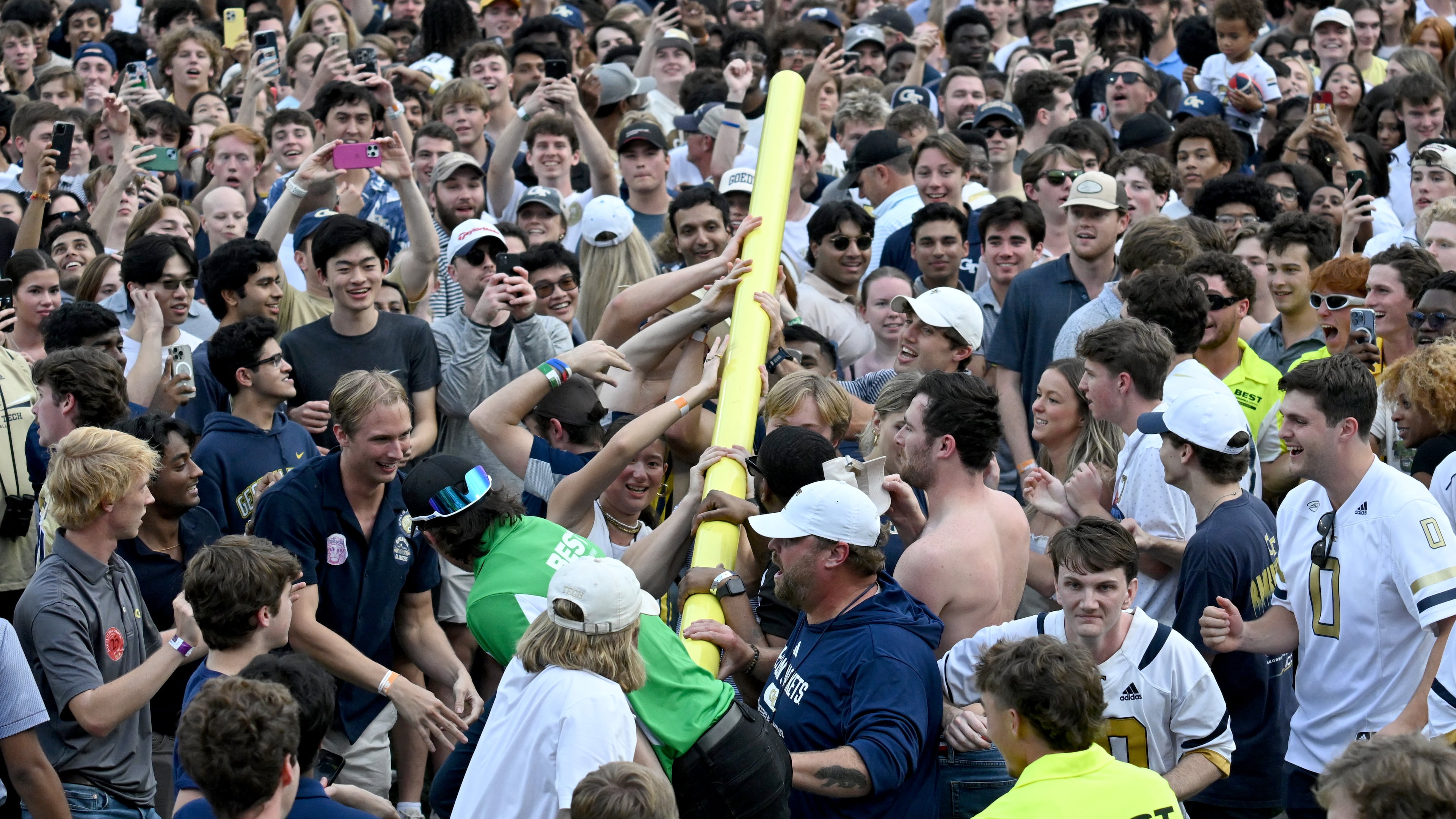 Georgia Tech fans try to lift a goalpost after an NCAA college football game against Miami at Georgia Tech's Bobby Dodd Stadium, Saturday, November 9, 2024, in Atlanta. Georgia Tech won 28-23 over Miami. (Hyosub Shin / AJC)