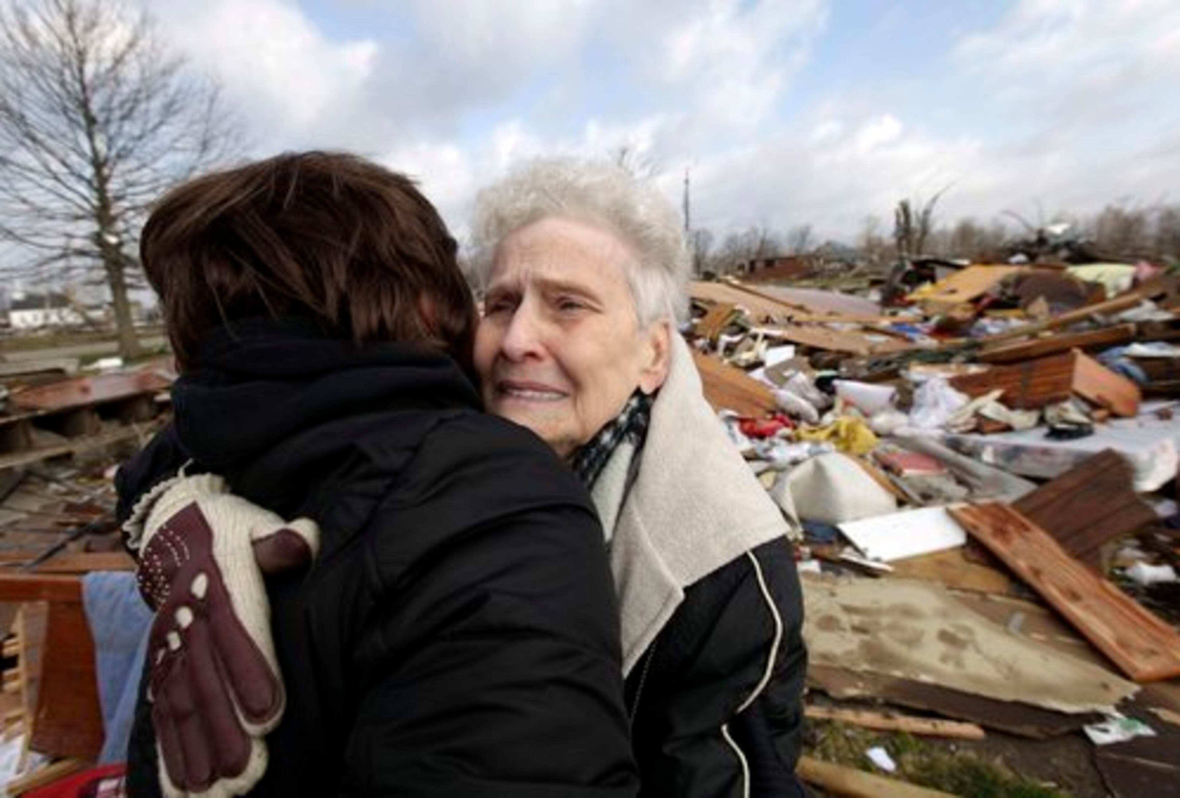 Marta Righthouse, right, cries as she hugs her neighbor Debbie Gilbert in Marysville, Ind., Saturday, March 3, 2012.