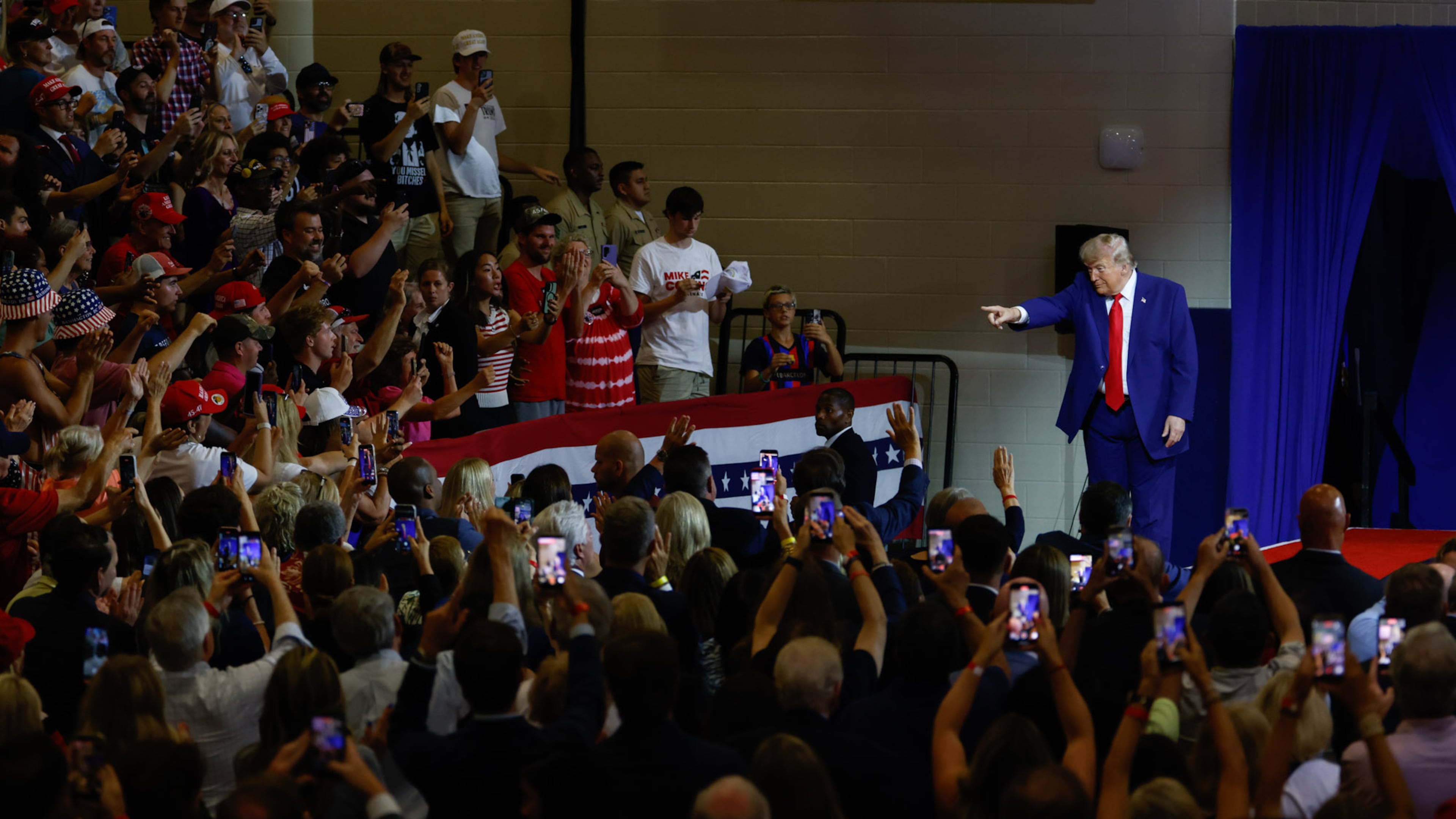 President Donald Trump points to the crowd after speaking at Wheeler High School in Marietta on Wednesday. (Arvin Temkar/AJC)