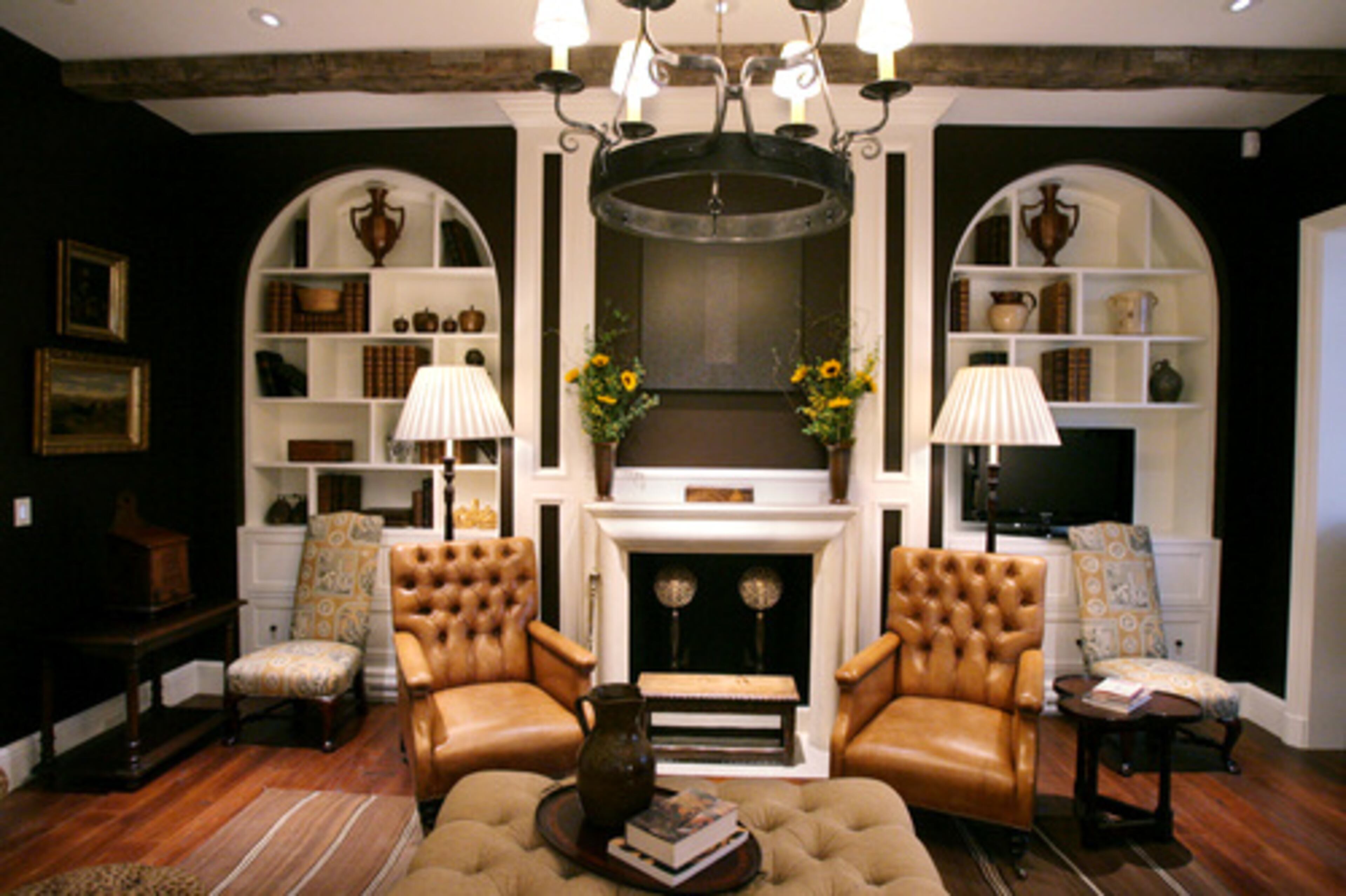 The keeping room across from the kitchen island is anchored by chocolate walls and rich fabrics. The travertine fireplace echoes a travertine hood on the opposite wall. Residential designers Yong Pak and Charles Heydt incorporated built-ins in several rooms to give the home a classic feel.