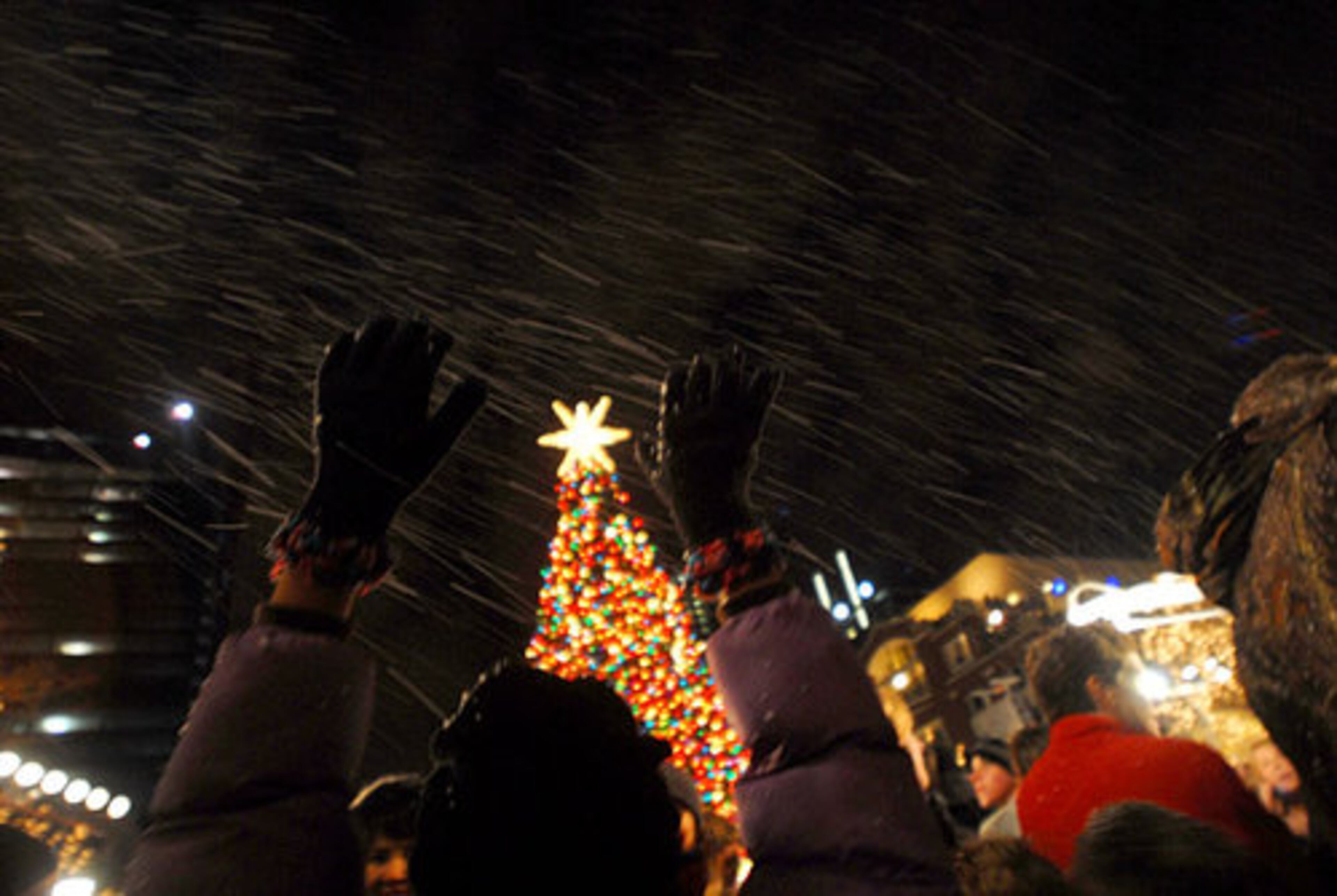 Fake snow flurries sweep through the air onto patrons.