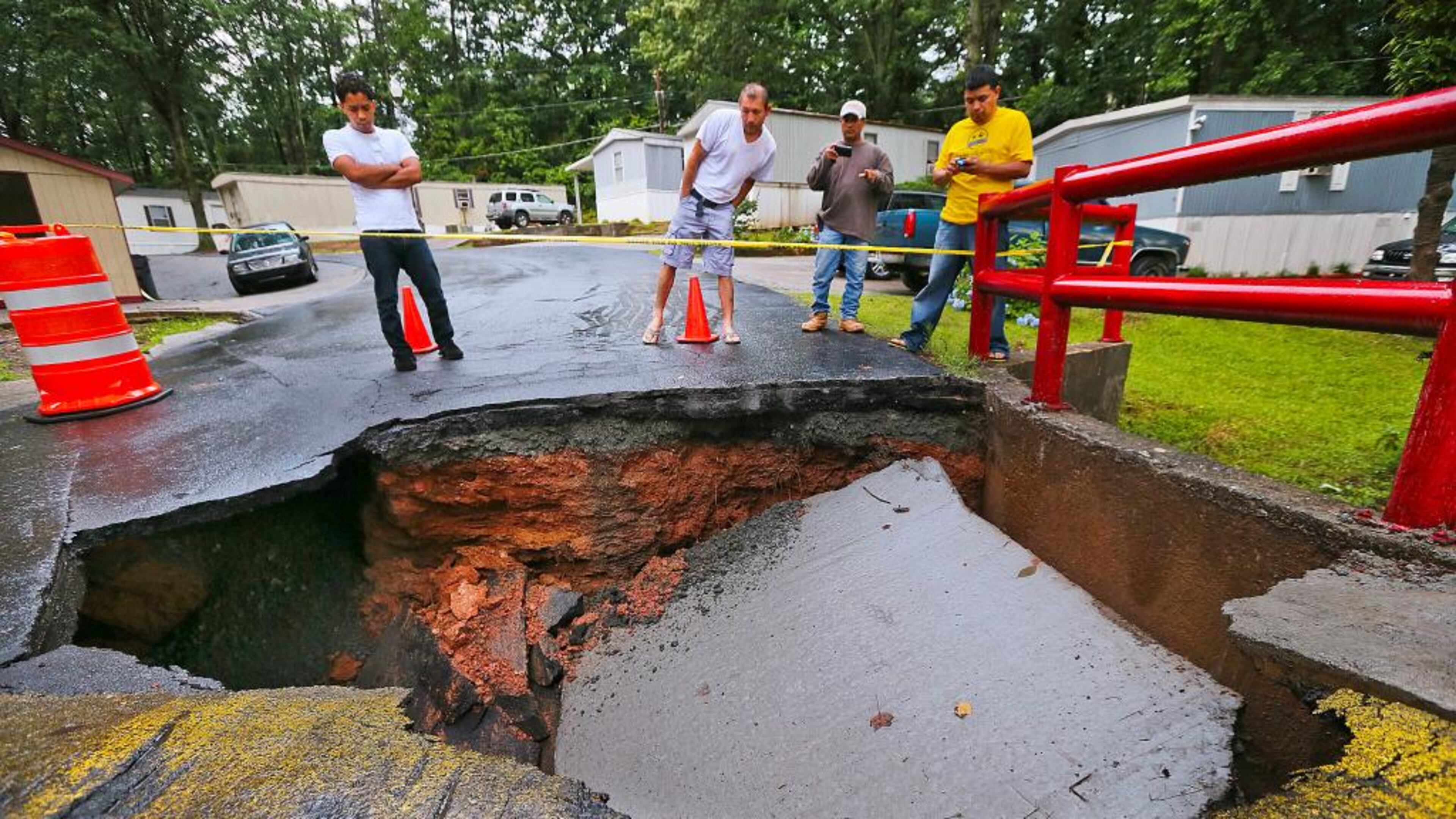 Resident of Pine Haven mobile home park near Marietta check out a section of collapsed roadway atop a small bridge leading to their homes.