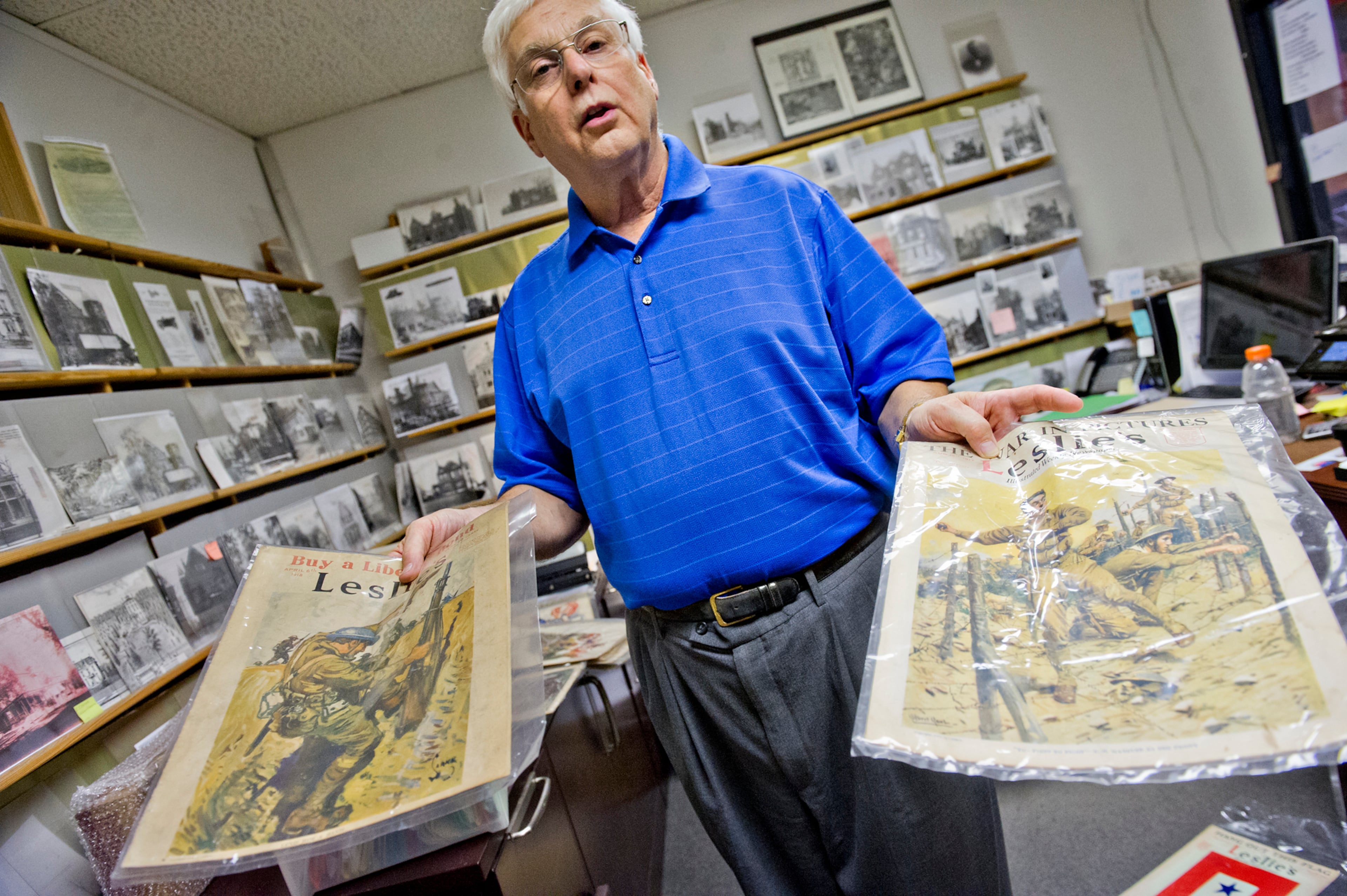 Steve Ehrlich holds up copies of Leslie's Illustrated Weekly Newspaper in his office in Marietta as he explains how the covers were created from 1917-1918 to garner support for World War I on Wednesday, July 2, 2014. Ehlrich, a historian, has close to 70 different issues of the newspaper. JONATHAN PHILLIPS / SPECIAL