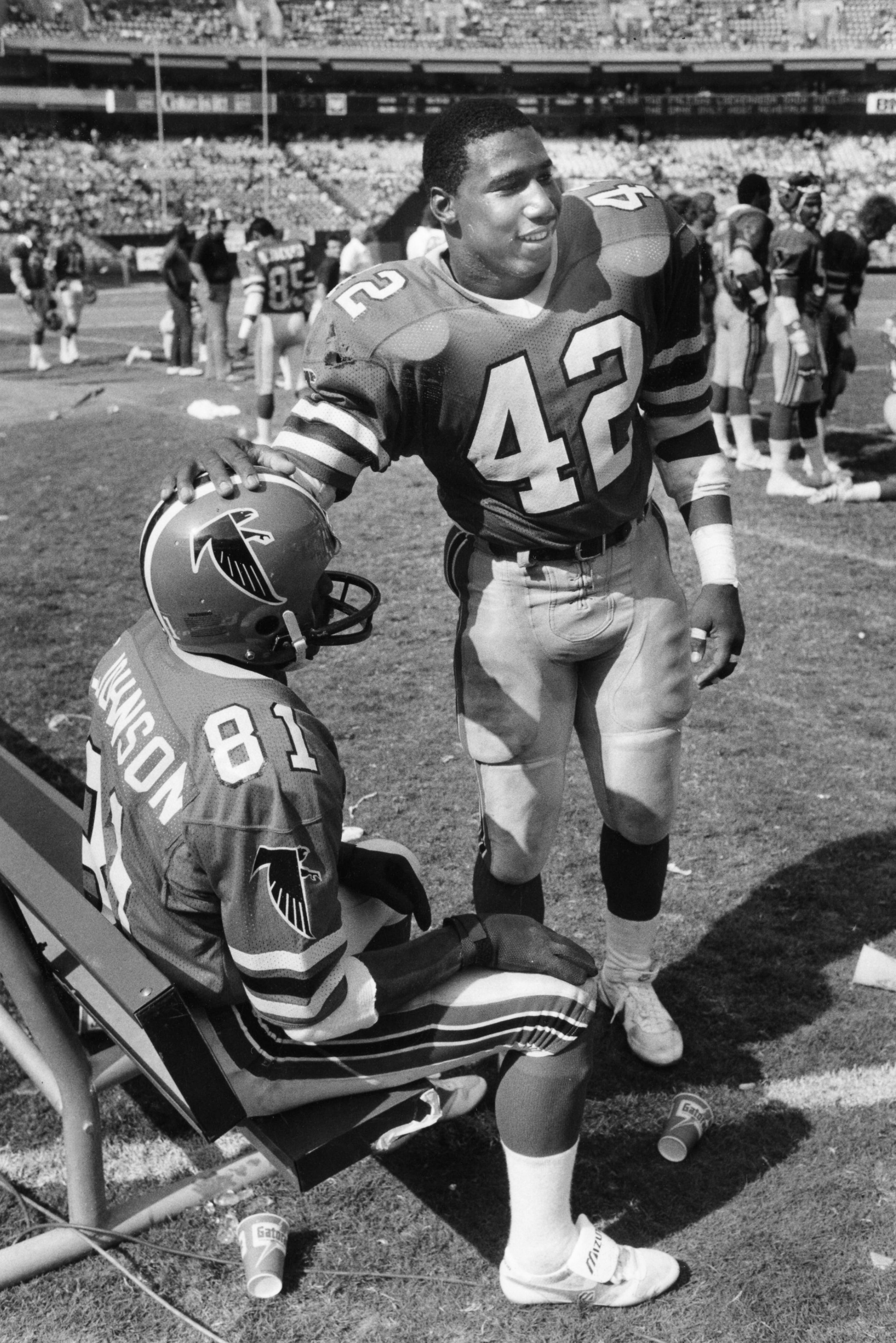 Riggs (right) and receiver Billy "White Shoes" Johnson take a break during a game in 1985. AJC file photo