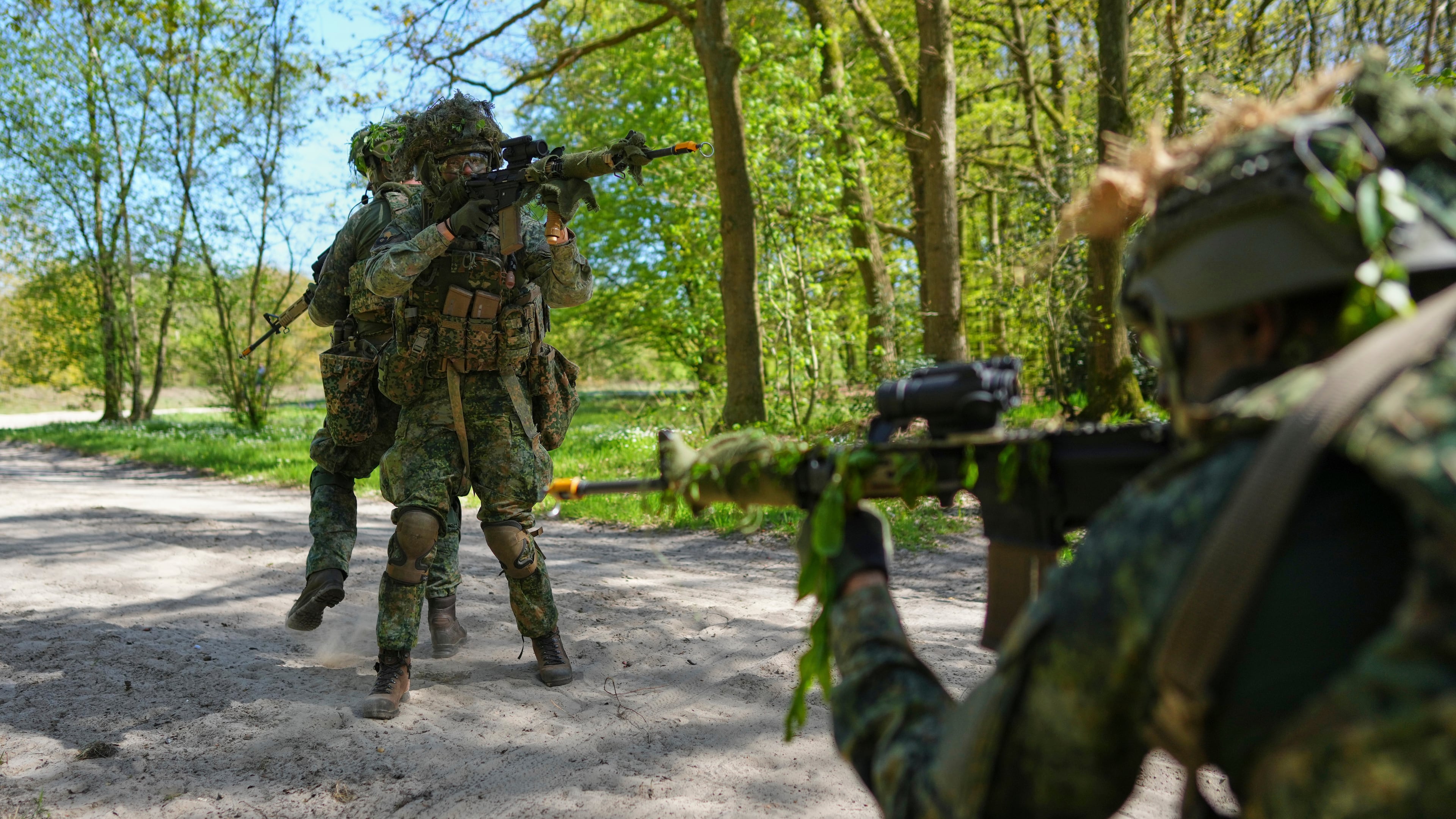 Members of the 10th Infantry Battalion Guard Security Corps National Reserve secure the crossing of a road during a weekend exercise to hone their military skills as the Netherlands beefs up its military with new recruits and volunteer reservists in Havelte, Netherlands, Saturday, April 25, 2026. (AP Photo/Peter Dejong)