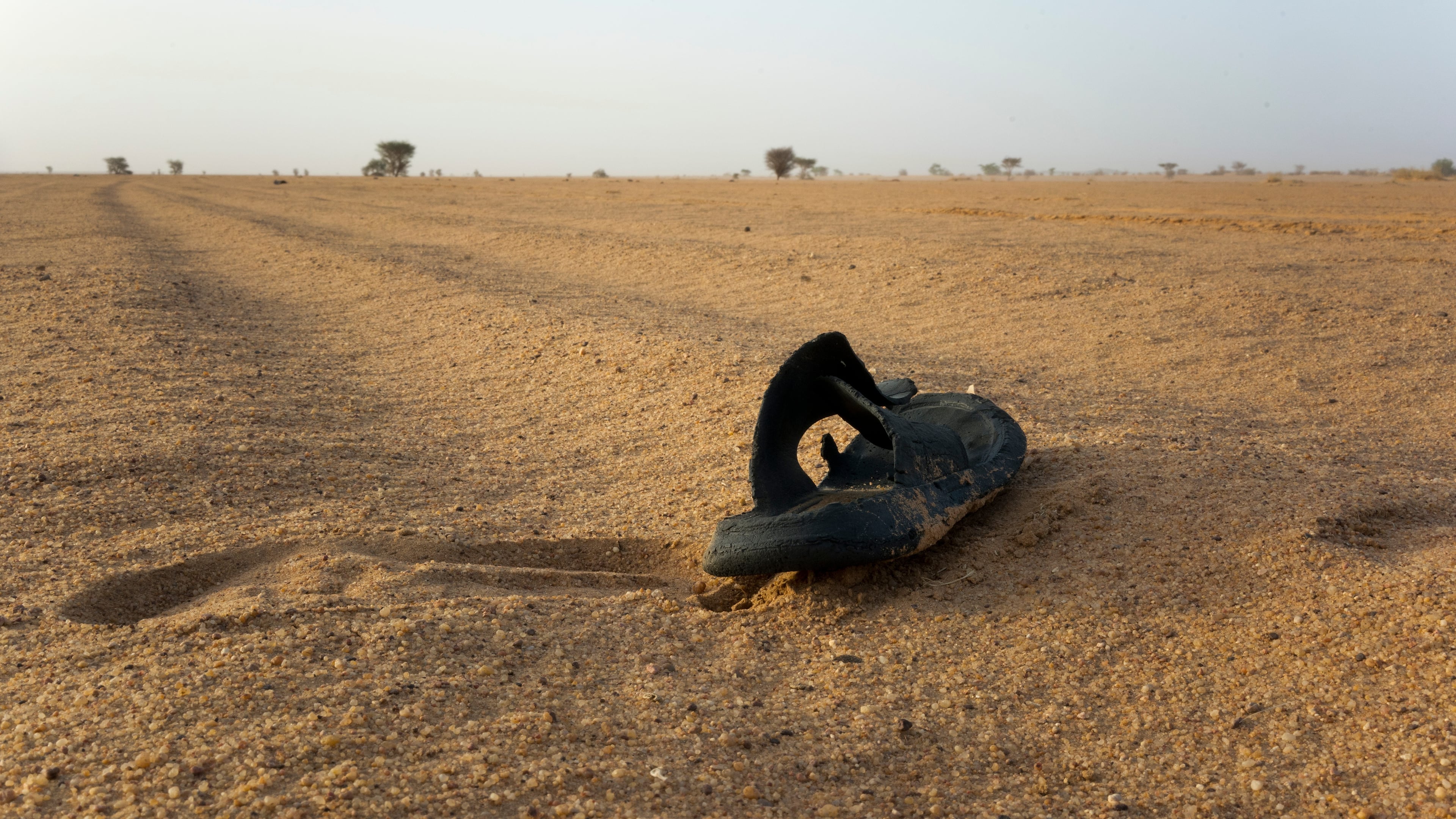 FILE - A sandal lies on the ground in Niger's desert region of the south central Sahara, Sunday, June 3, 2018. (AP Photo/Jerome Delay, File)