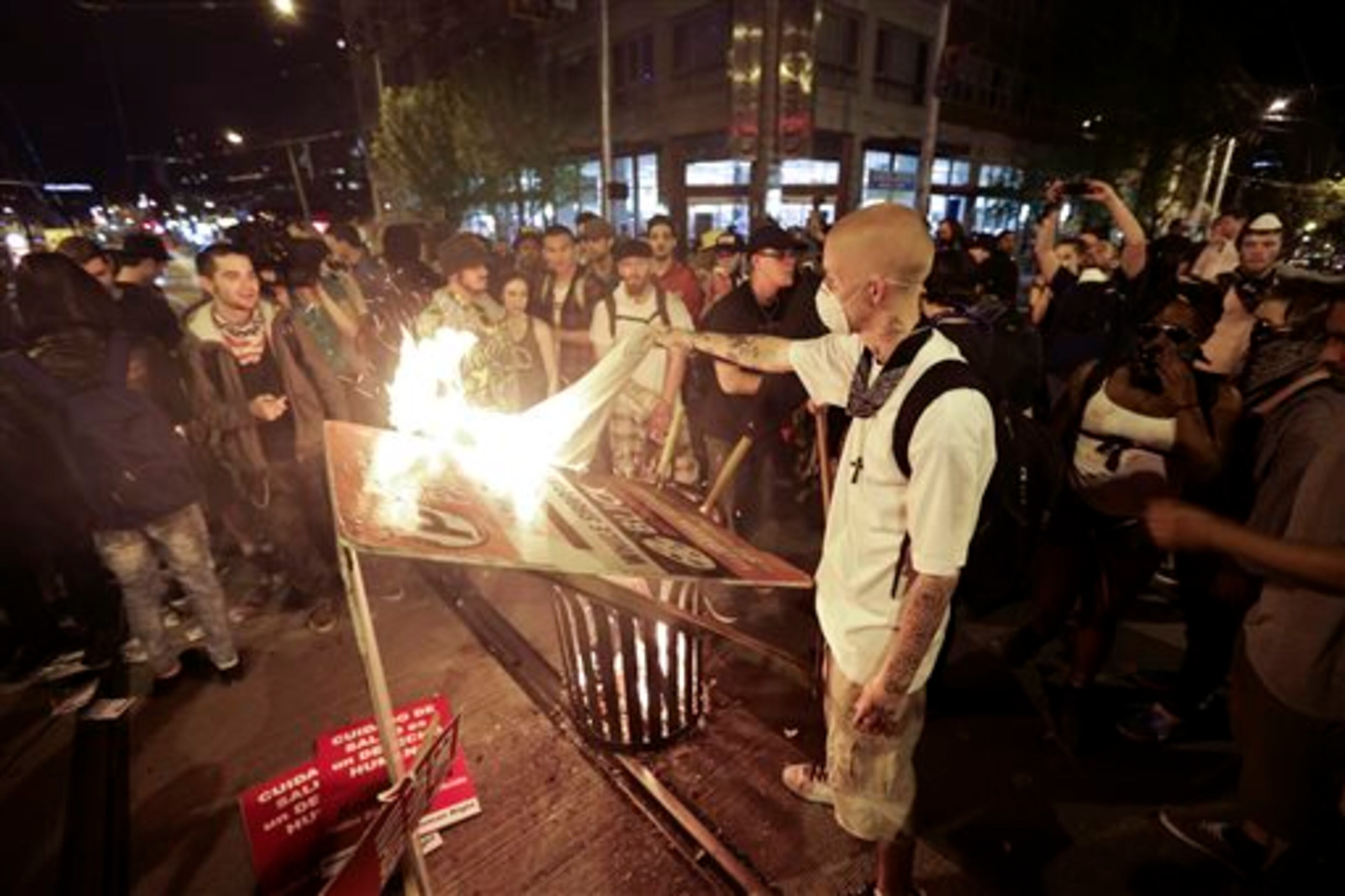 Protesters burn signs during May Day activities Thursday, May 1, 2014 in Seattle. Police have made several arrests and fired pepper spray as anti-capitalist marchers meandered through Seattle several hours after hundreds of peaceful demonstrators took part in a May Day march in support of immigrant rights and a boost in the minimum wage. (AP Photo/Ted S. Warren)