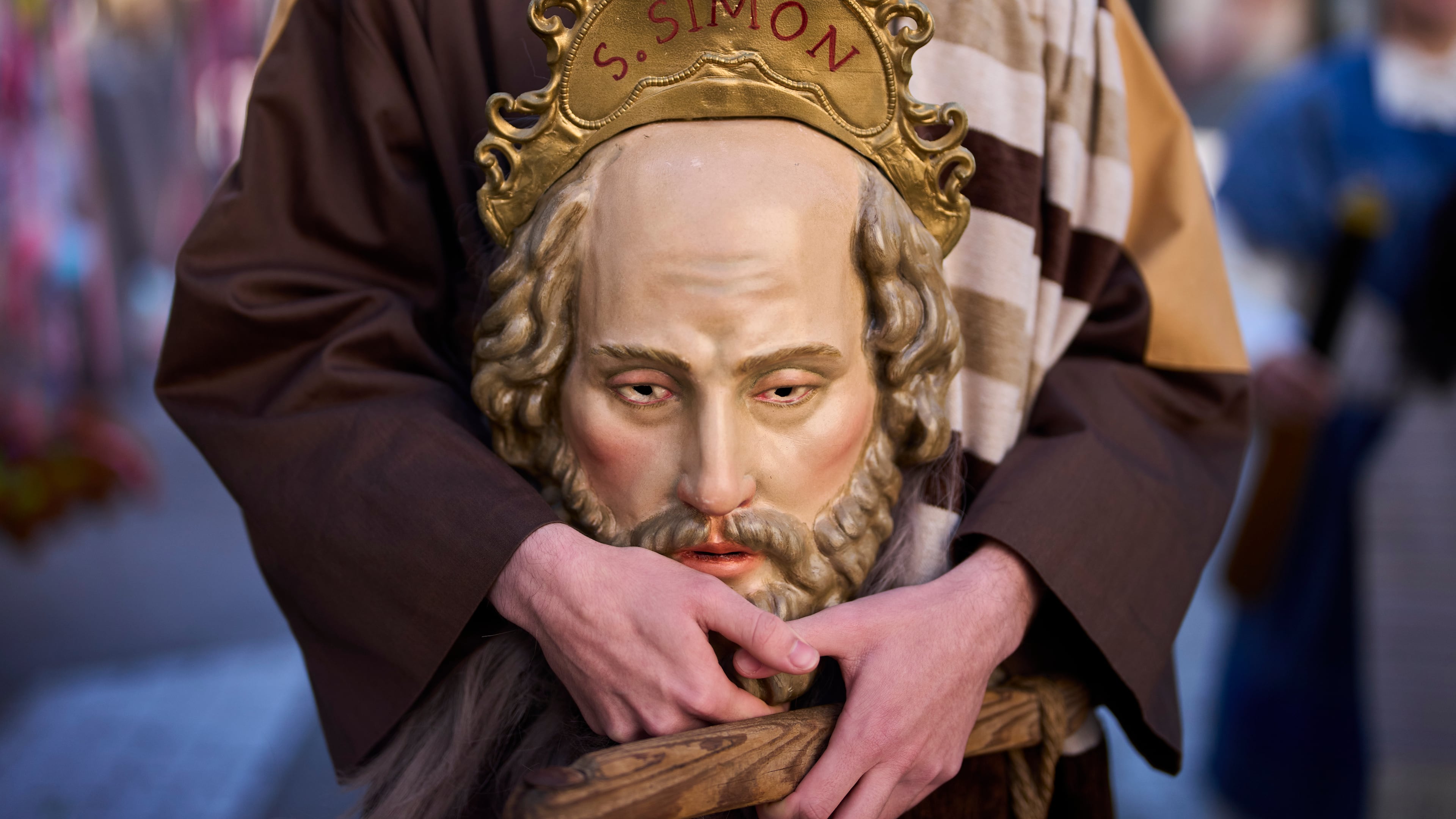 A penitent of the 'Pollinita' brotherhood, dressed in a typical Apostle costume, holds an image symbolizing the apostles during the Holy Week procession in Cabra, southern Spain, Sunday, March 29, 2026. (AP Photo/Manu Fernandez)