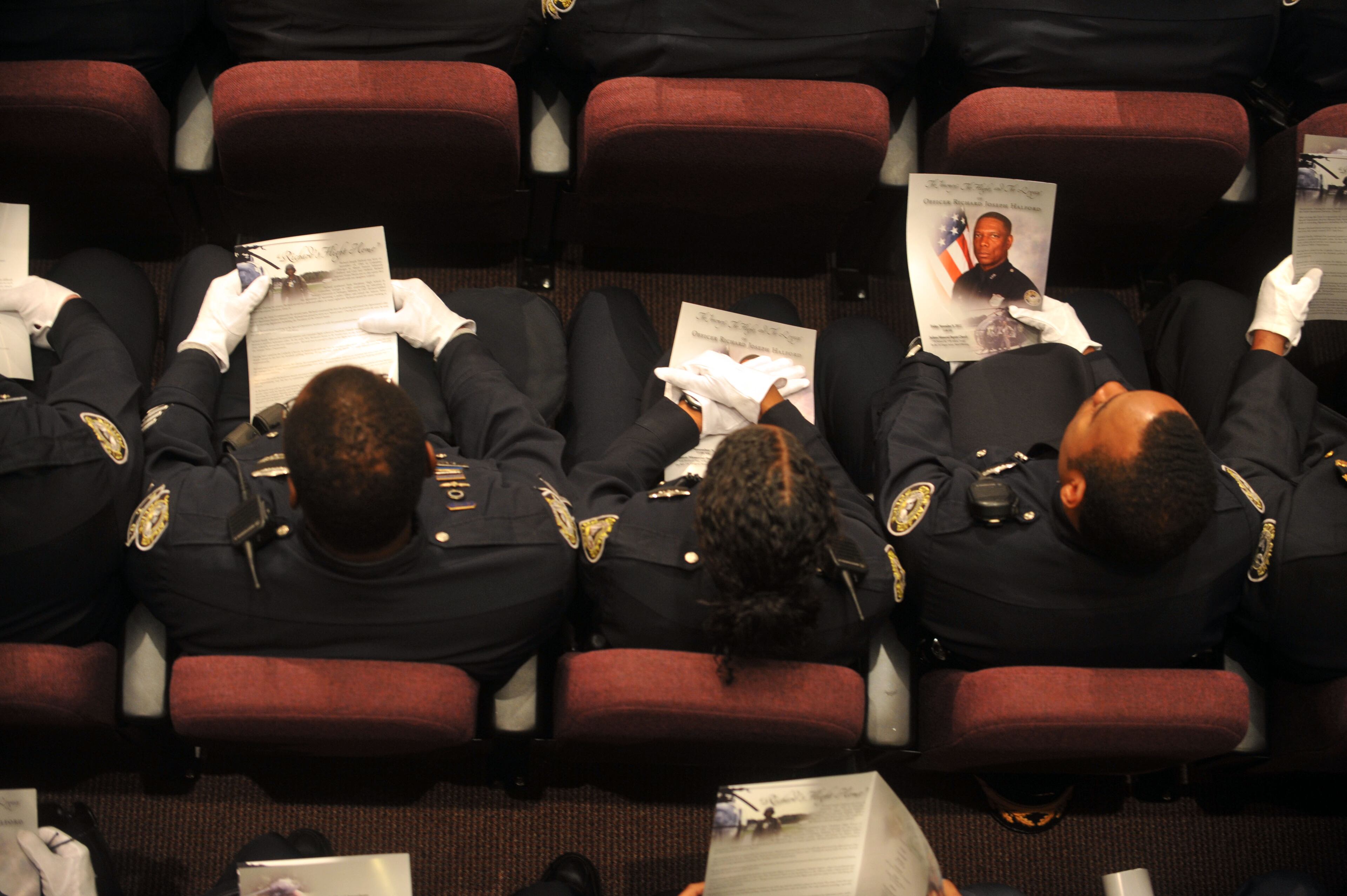 Officers read the program before the start of APD Officer Richard Halford's funeral services on Friday, November 9th at Jackson Memorial Baptist Church.