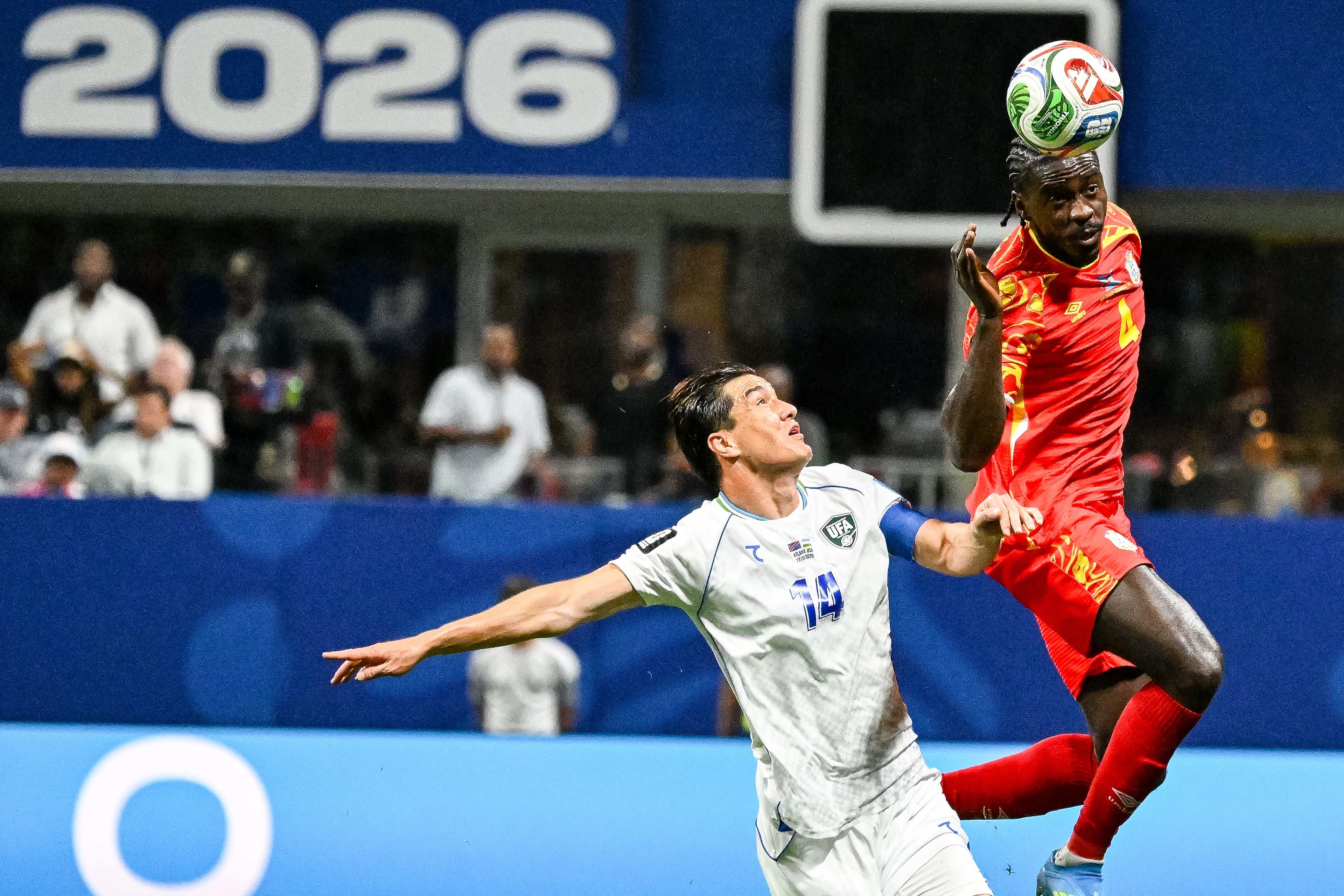 Congo defender Axel Tuanzebe (right) heads the ball away in front of Uzbekistan forward Eldor Shomurodov (left) during the first half of a FIFA World Cup match at Atlanta Stadium (Mercedes-Benz Stadium) on Saturday, June 27, 2026, in Atlanta. (Hyosub Shin/AJC)
