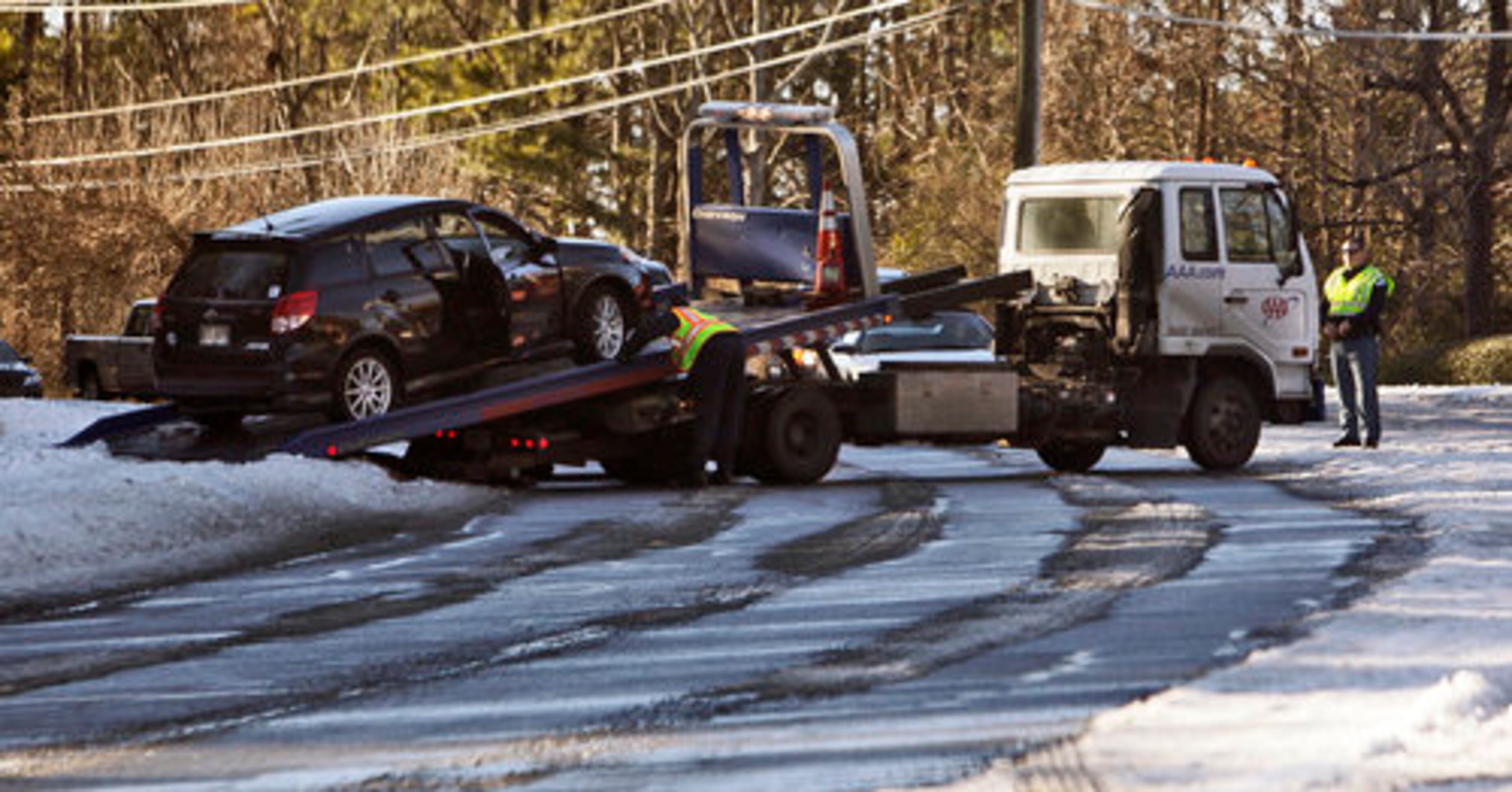 Despite the slow thaw Friday, some dangerous icy patches remained on area roads like this section of Shallowford Road in East Cobb, where a car is being towed.