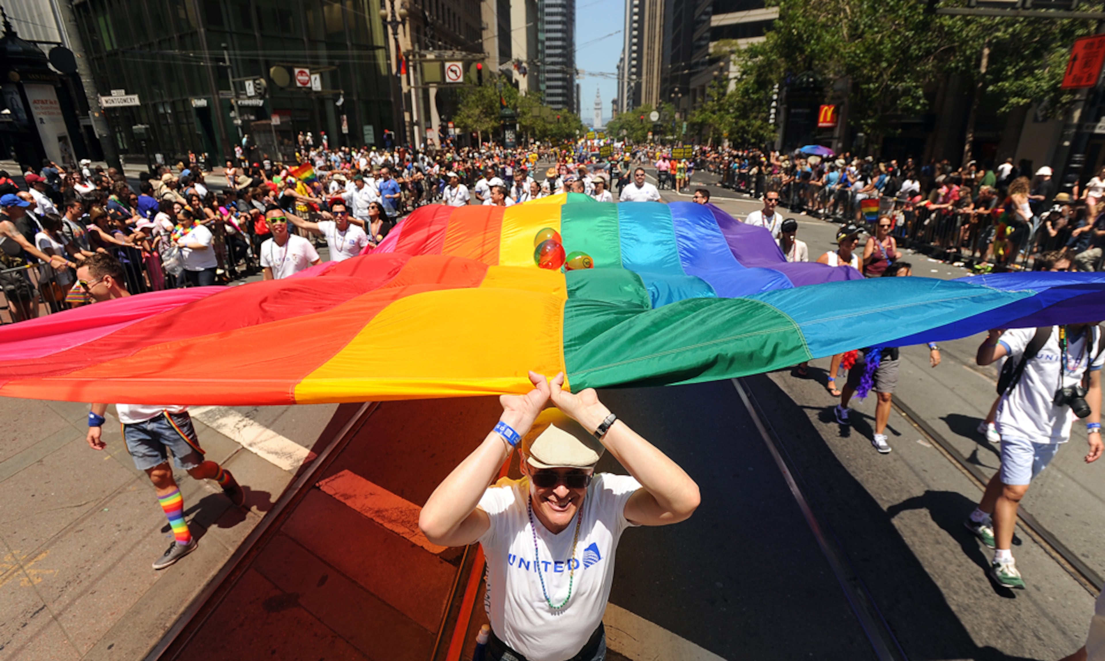 Alan Boyle helps carry a rainbow flag up Market Street during San Francisco's 43rd annual Gay Pride parade on Sunday, June 30, 2013. (AP Photo/Noah Berger)