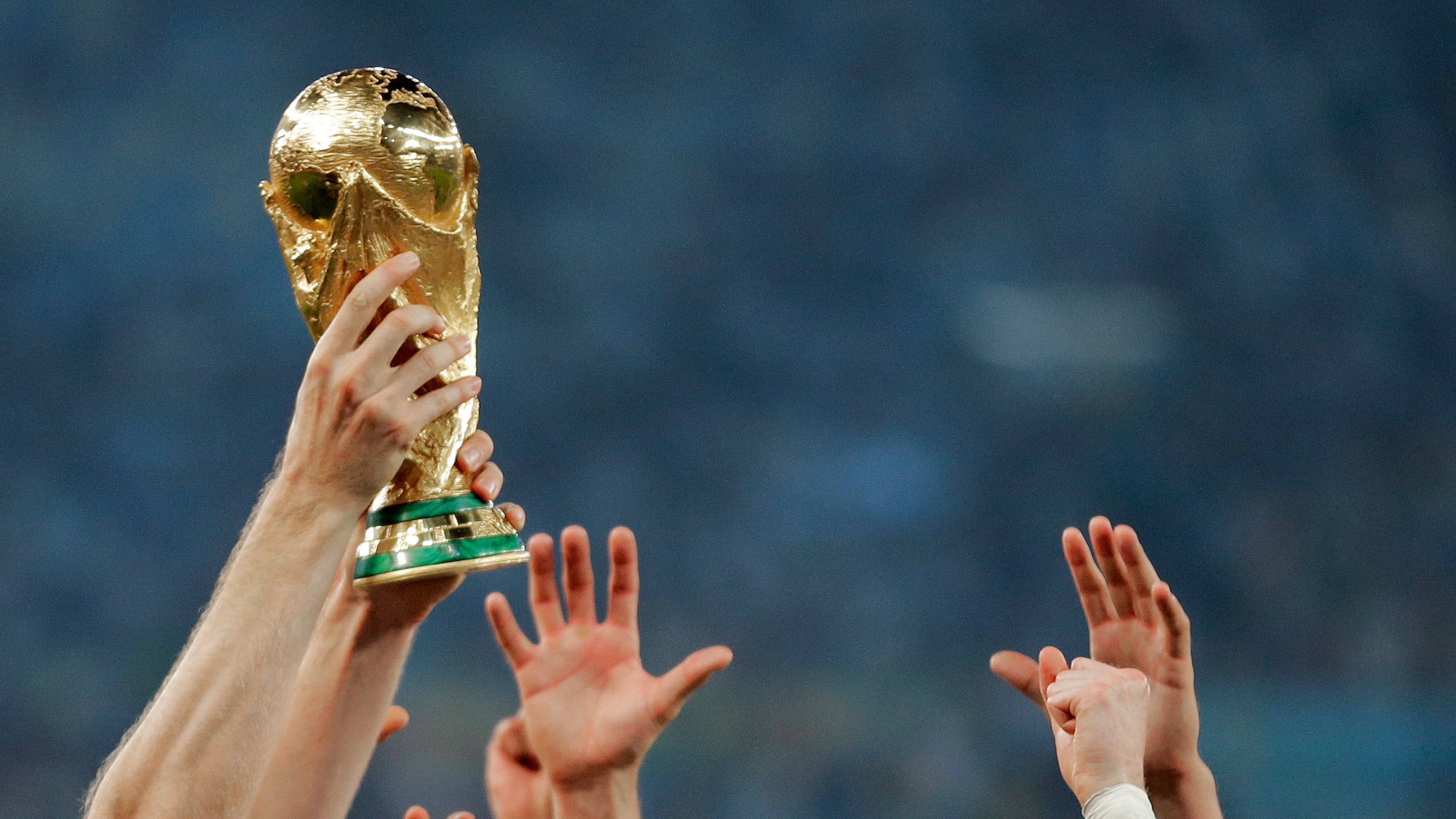 FILE - German players reach out to touch the trophy after the World Cup final soccer match between Germany and Argentina, in Rio de Janeiro, Brasil, July 13, 2014. (AP Photo/Matthias Schrader, File)