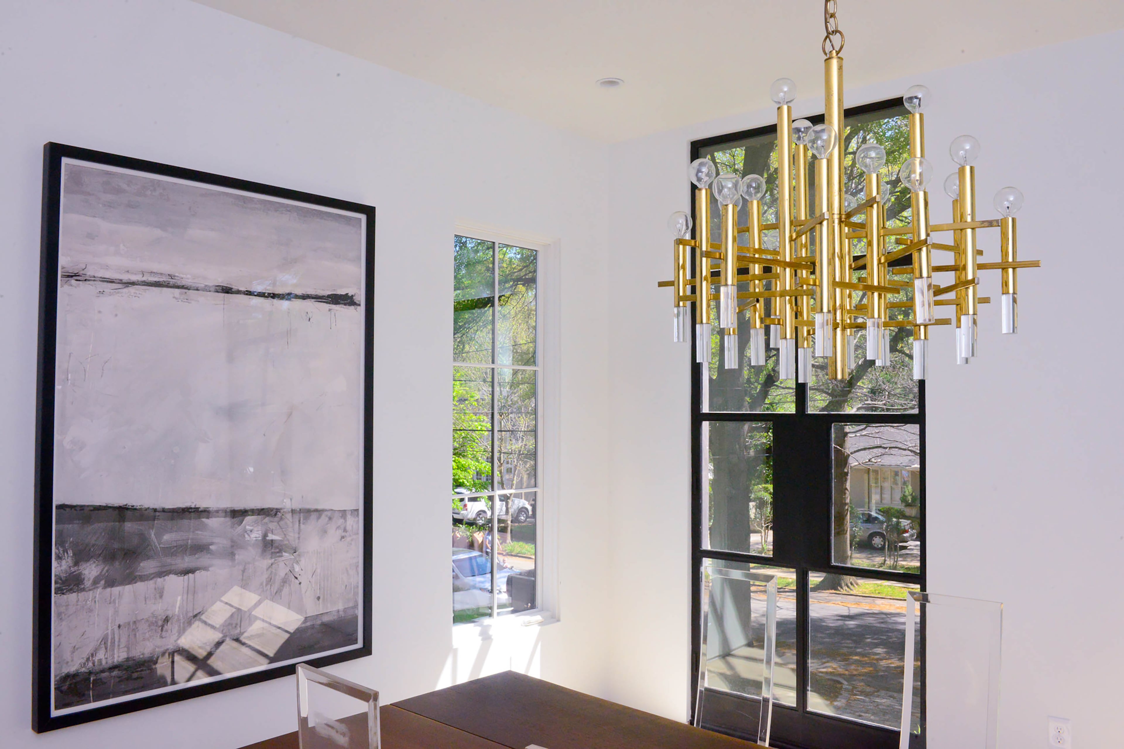 A brass Scolari chandelier, from Anne Flaire Antiques, shines above the dining room table, giving the space a pop of midcentury style and color.