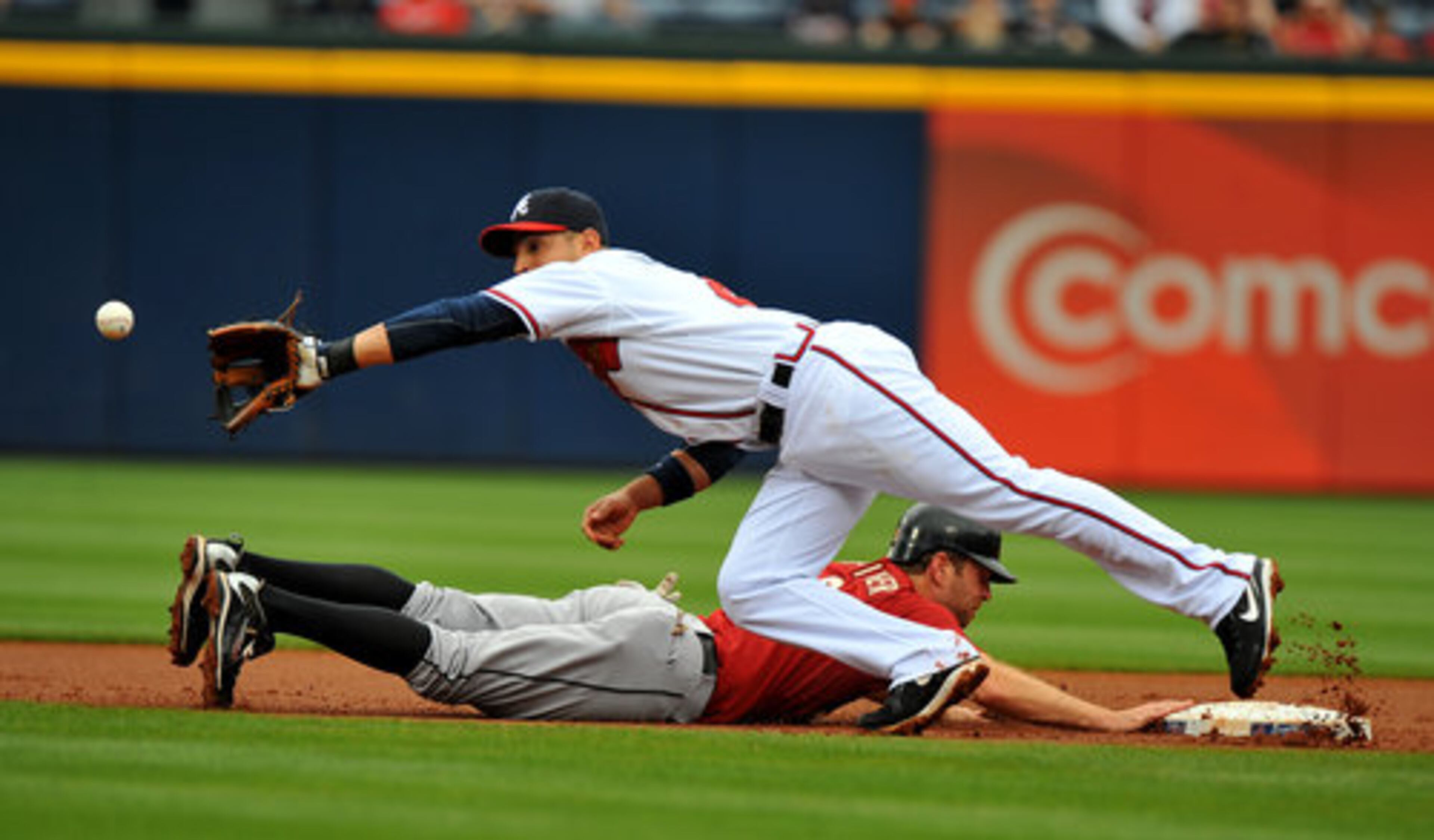 Houston Astros base runner Jeff Keppinger dives back into second as Braves shortstop Omar Infante reaches for the throw from catcher David Ross. Ross made the throw after a pitch, attempting to take advantage of the Keppinger's large lead Saturday May 1, 2010 at Turner Field.