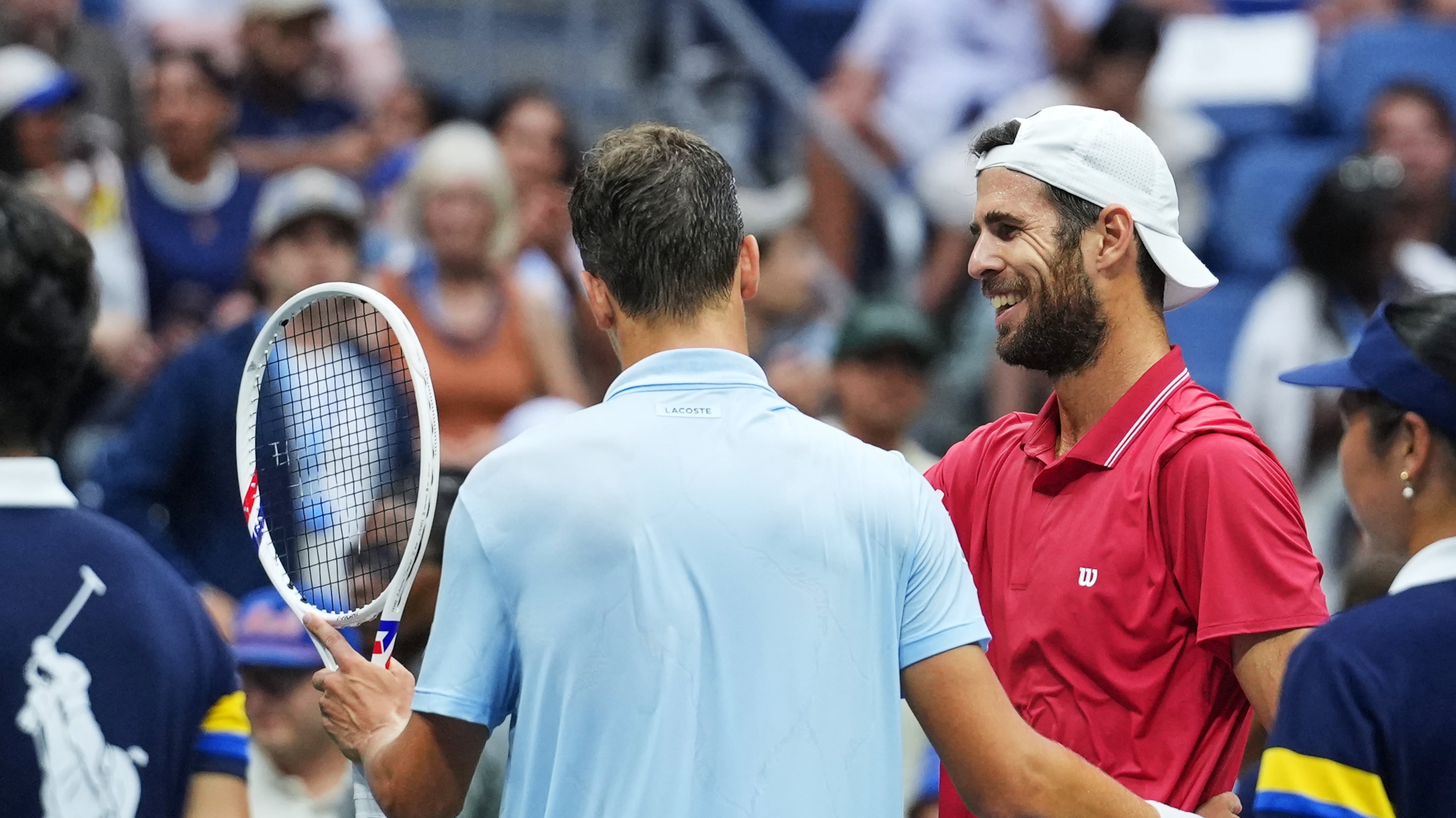 Alexander Blockx, of Belgium, left, meets Karen Khachanov, of Russia, at the net after Blockx was forced to retire due to an apparent injury during the quarterfinal round of the U.S. Open tennis championships, Wednesday, Sept. 9, 2026, in New York. (AP Photo/Kirsty Wigglesworth)