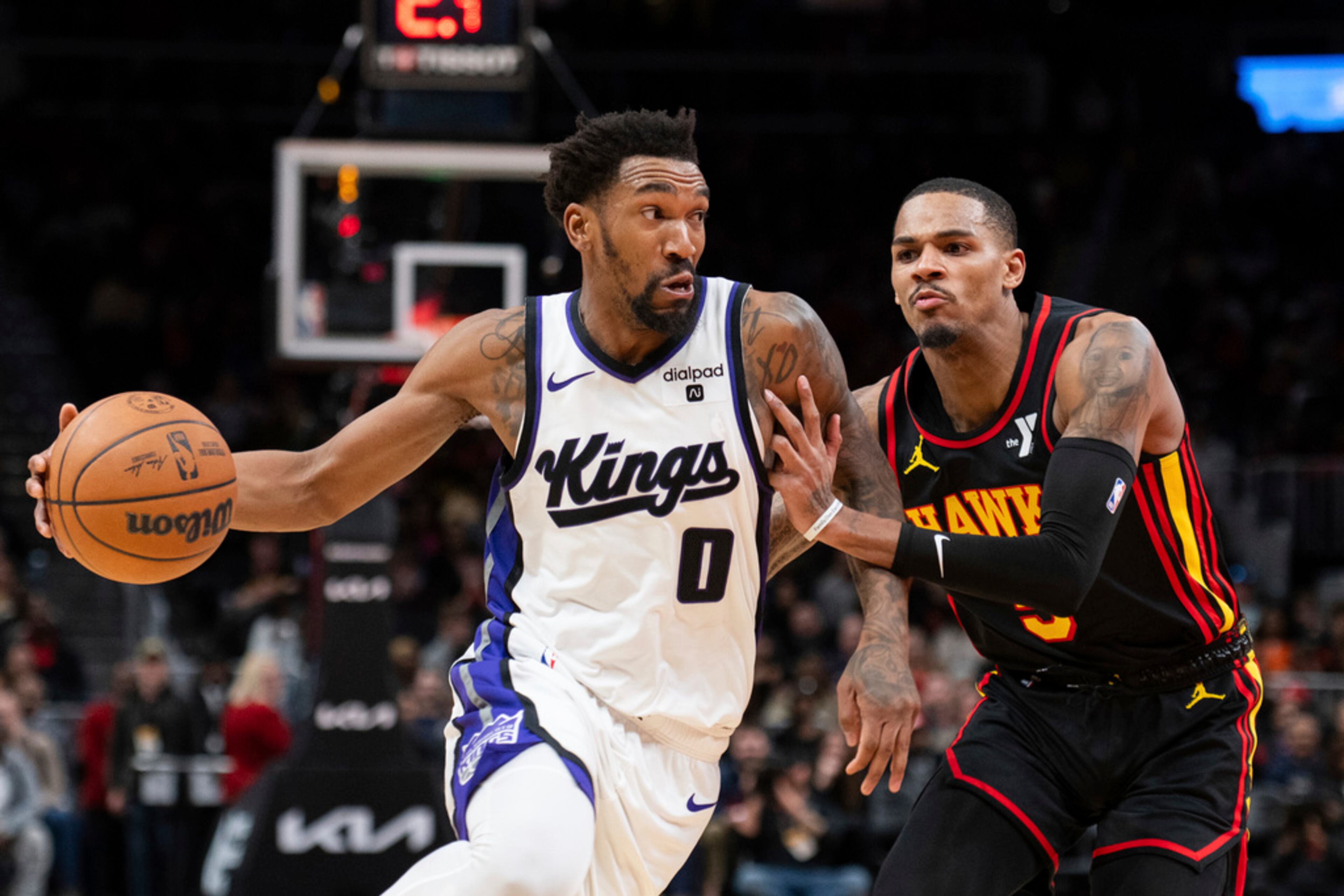 Sacramento Kings guard Malik Monk (0) drives against Atlanta Hawks guard Dejounte Murray, right, during the second half of an NBA basketball game Friday, Dec 29, 2023, in Atlanta. The Hawks lost 117-110. (AP Photo/Hakim Wright Sr.)