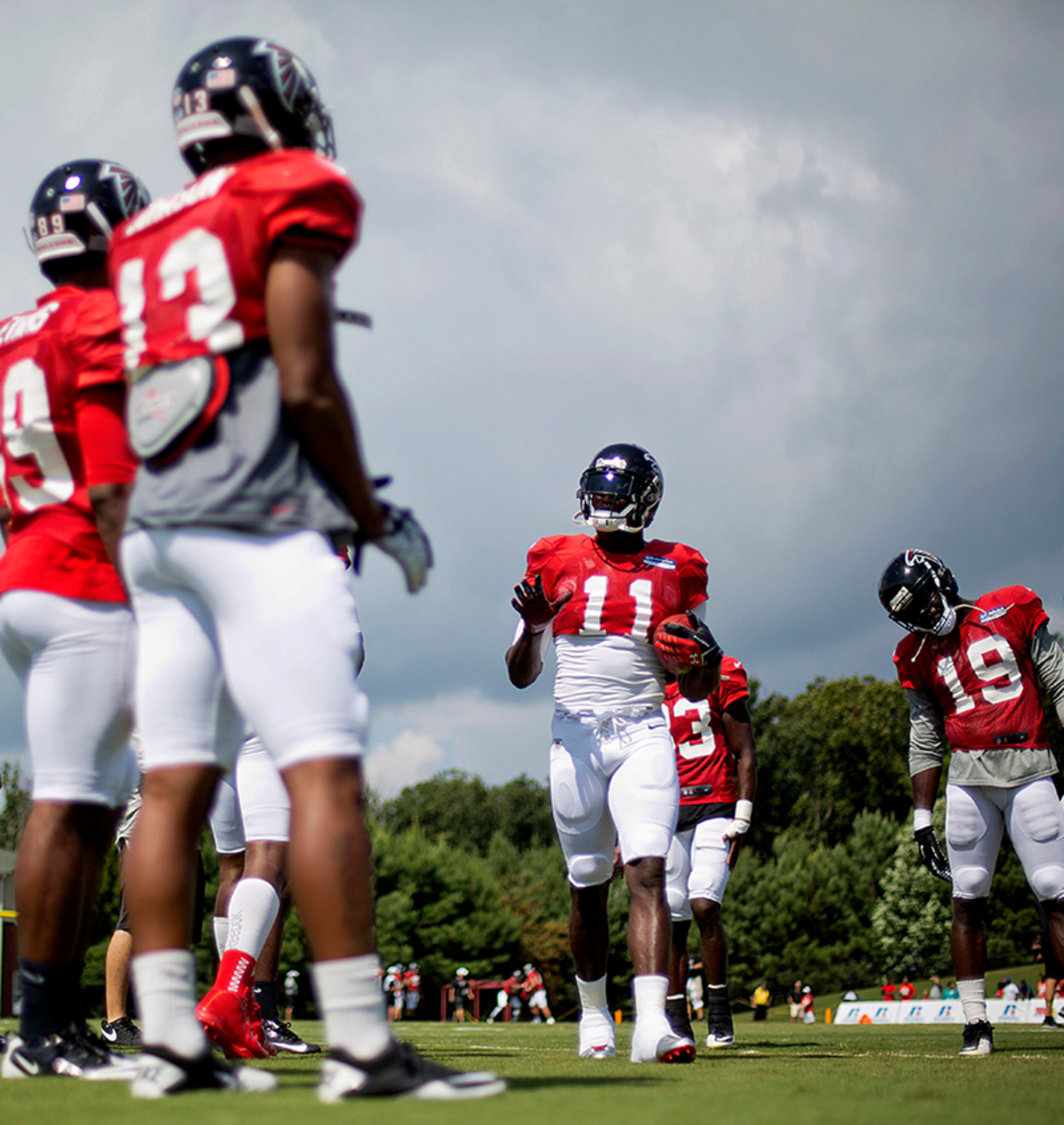Falcons wide receiver Julio Jones (center) jokes with teammates during practice Thursday, Aug. 1, 2013, in Flowery Branch.