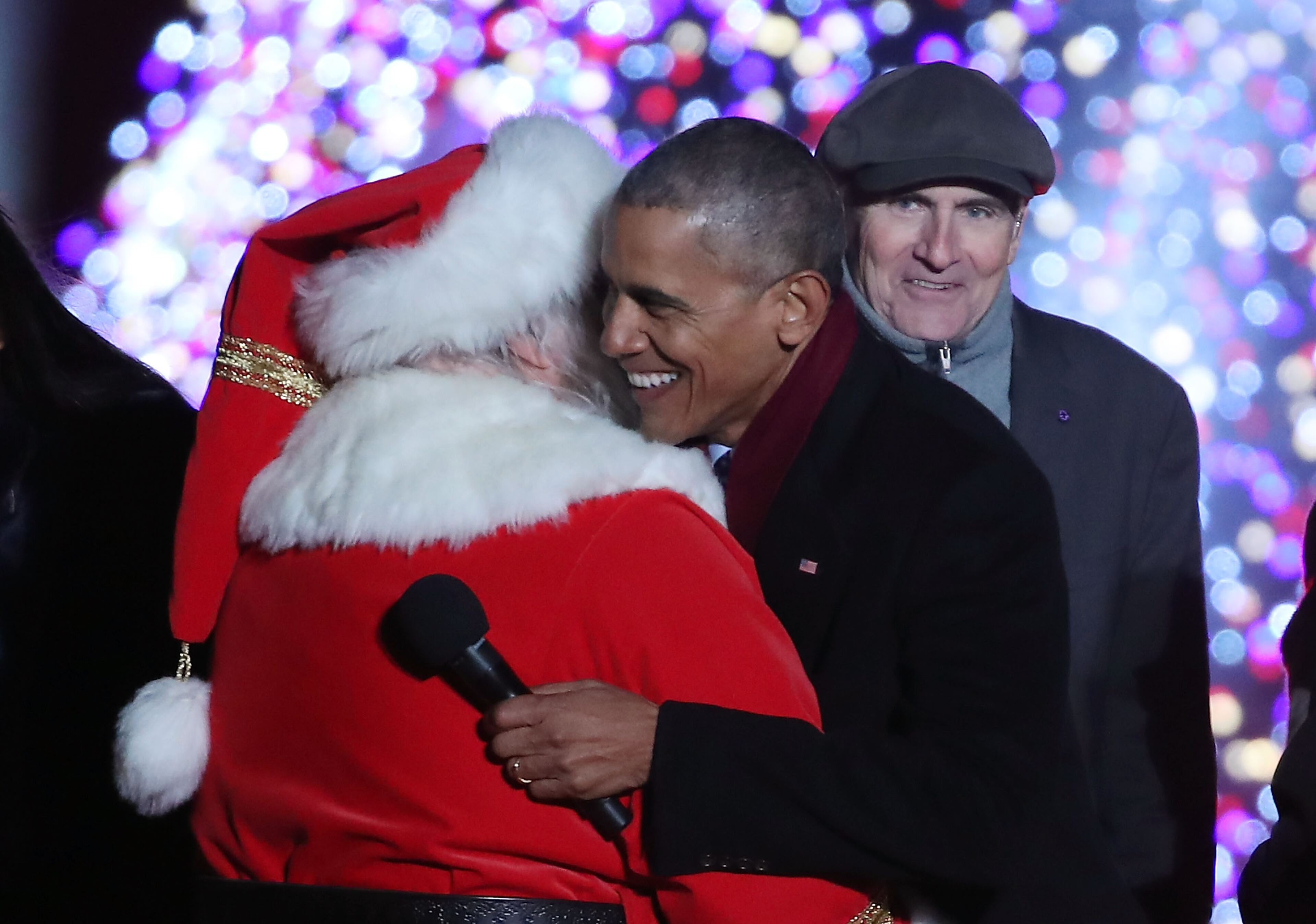 WASHINGTON, DC - DECEMBER 01: U.S. President Barack Obama gets a hug from Santa Claus as musician James Taylor looks on during the National Christmas Tree lighting ceremony, on December 1, 2016 in Washington, DC. This year is the 94th annual National Christmas Tree Lighting Ceremony. (Photo by Mark Wilson/Getty Images)