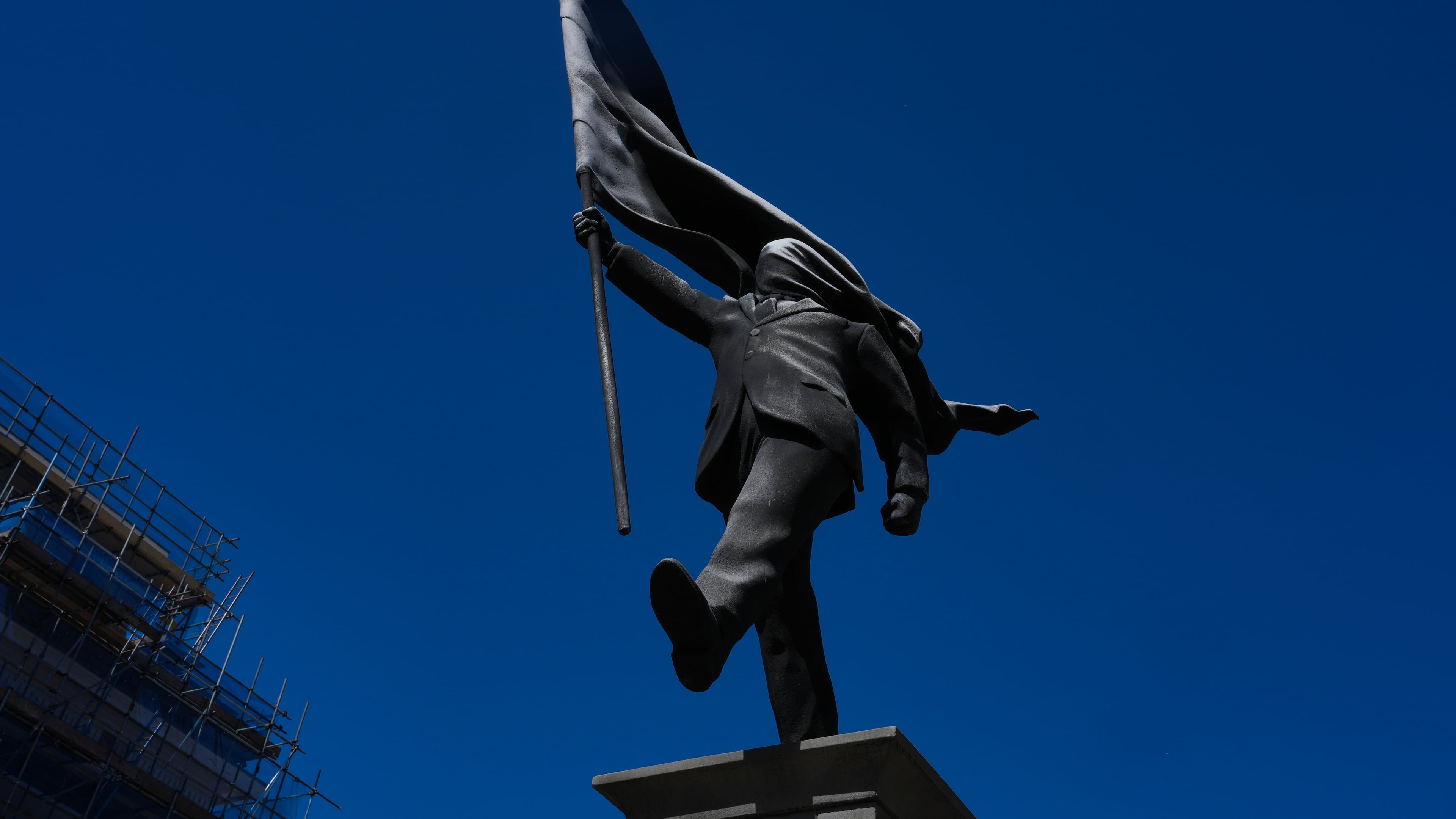 A statue of a man holding a flag covering his face, and signed 'Banksy', which has appeared in Waterloo Place in London, Thursday, April 30, 2026. (AP Photo/Kin Cheung)