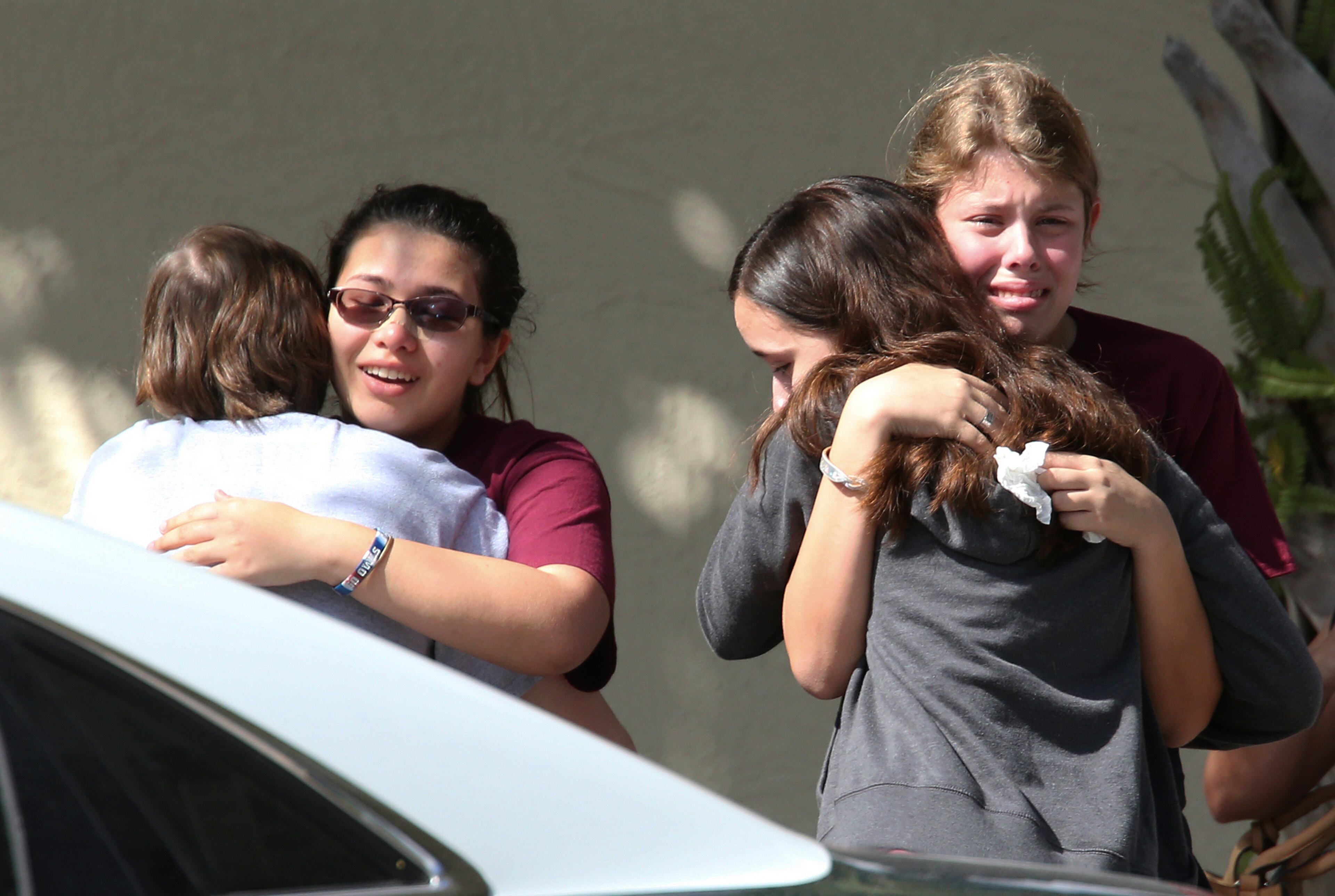 Students grieve outside Pines Trail Center where counselors are present, after Wednesday's mass shooting at Marjory Stoneman Douglas High School in Parkland, Fla., Thursday, Feb. 15, 2018. Nikolas Cruz was charged with 17 counts of premeditated murder Thursday morning. (AP Photo/Joel Auerbach)