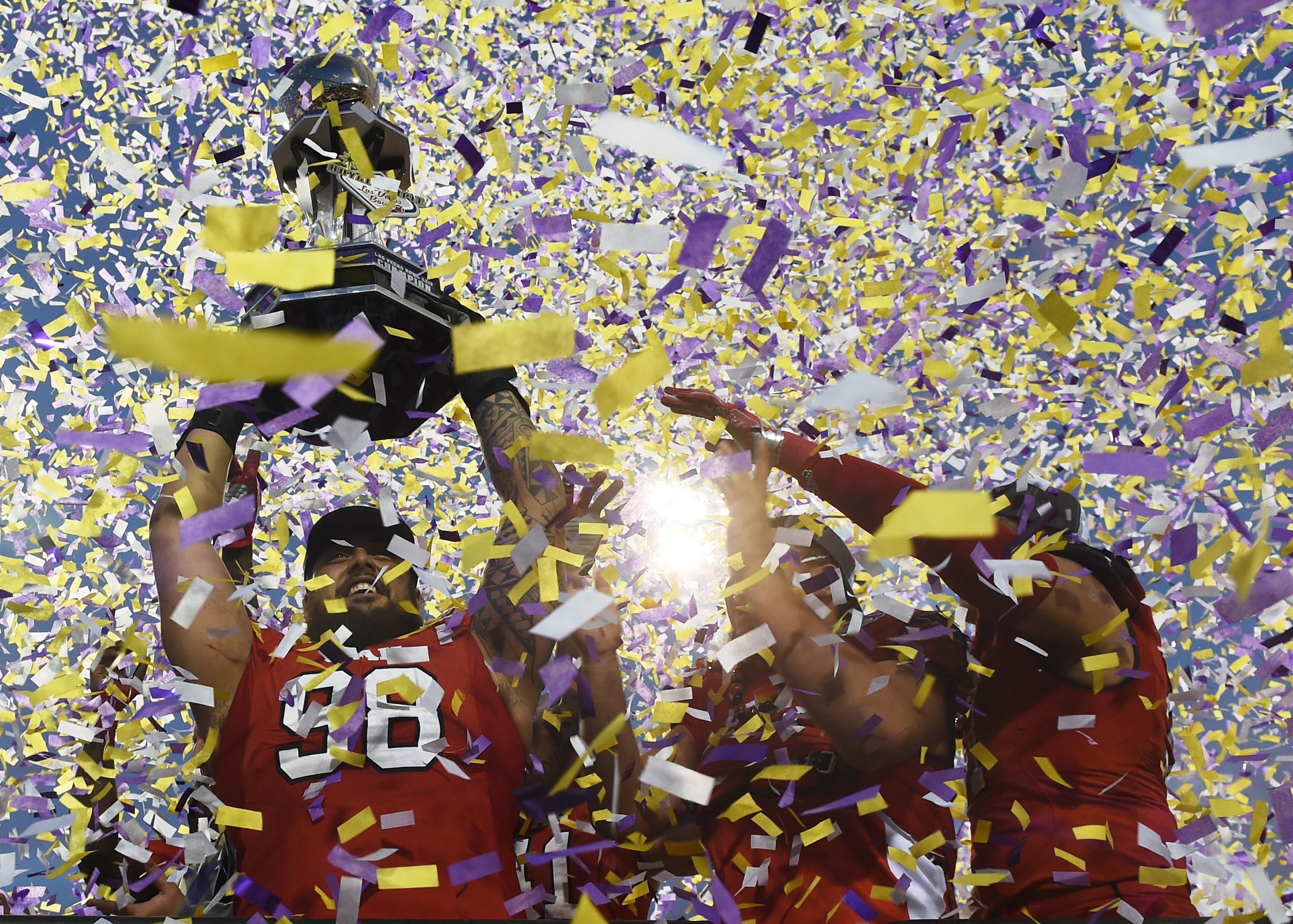 LAS VEGAS, NV - DECEMBER 19: (L-R) Defensive tackle Viliseni Fauonuku #98, offensive lineman Siaosi Aiono #60 and defensive end Jason Fanaika #51 of the Utah Utes celebrate with the championship trophy after defeating the Brigham Young Cougars 35-28 to win the Royal Purple Las Vegas Bowl at Sam Boyd Stadium on December 19, 2015 in Las Vegas, Nevada. (Photo by Ethan Miller/Getty Images)