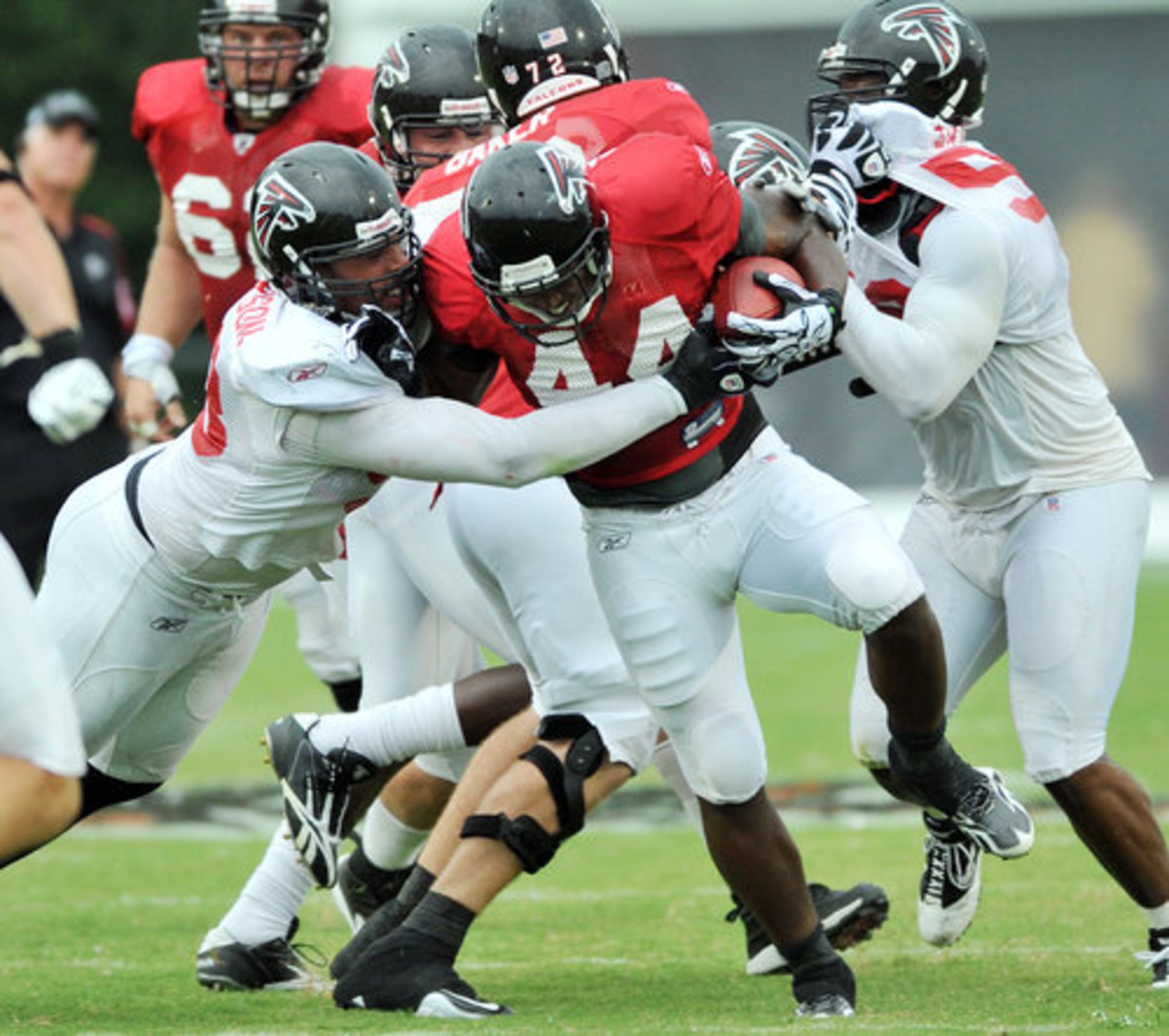 Atlanta Falcons's Jamaal Anderson (left, 98) takes down Jason Snelling (44) during the Friday Night Lights at North Gwinnett High School in Suwanee.