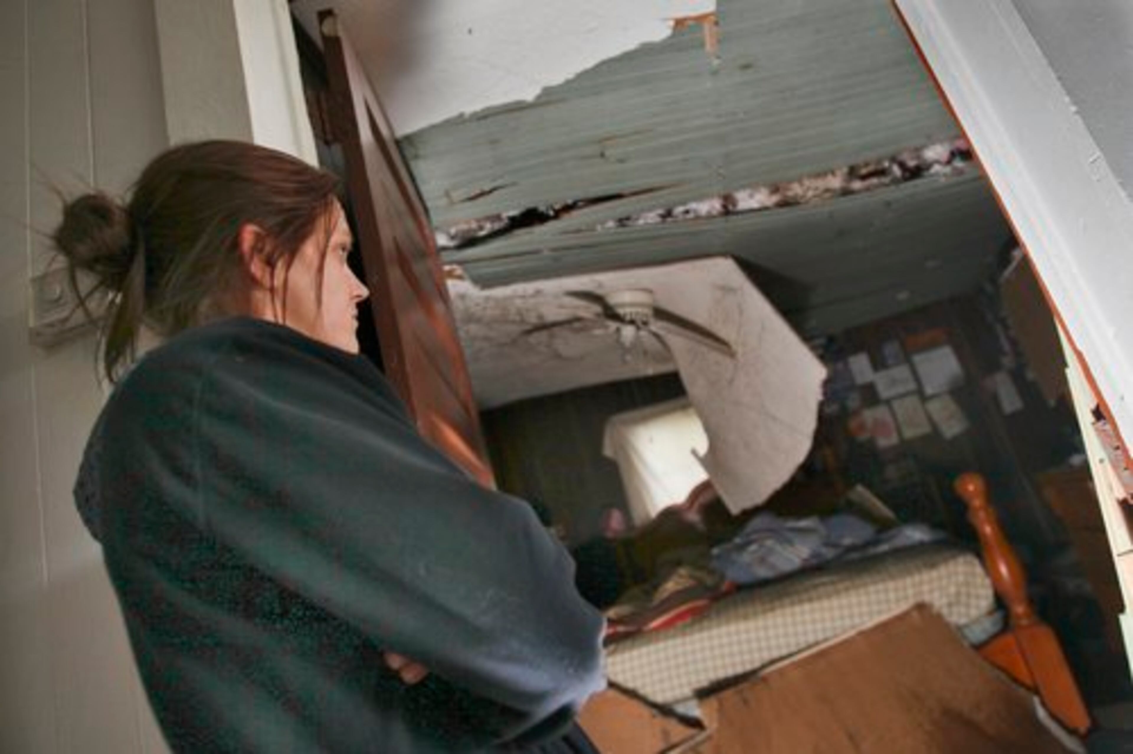 Rebecca Coleman looks at the roof of her bedroom where a tree cashed through overnight Thursday on Old Atlanta Road in Sunny Side. She and her family huddled in the bathroom as the storm blew through.