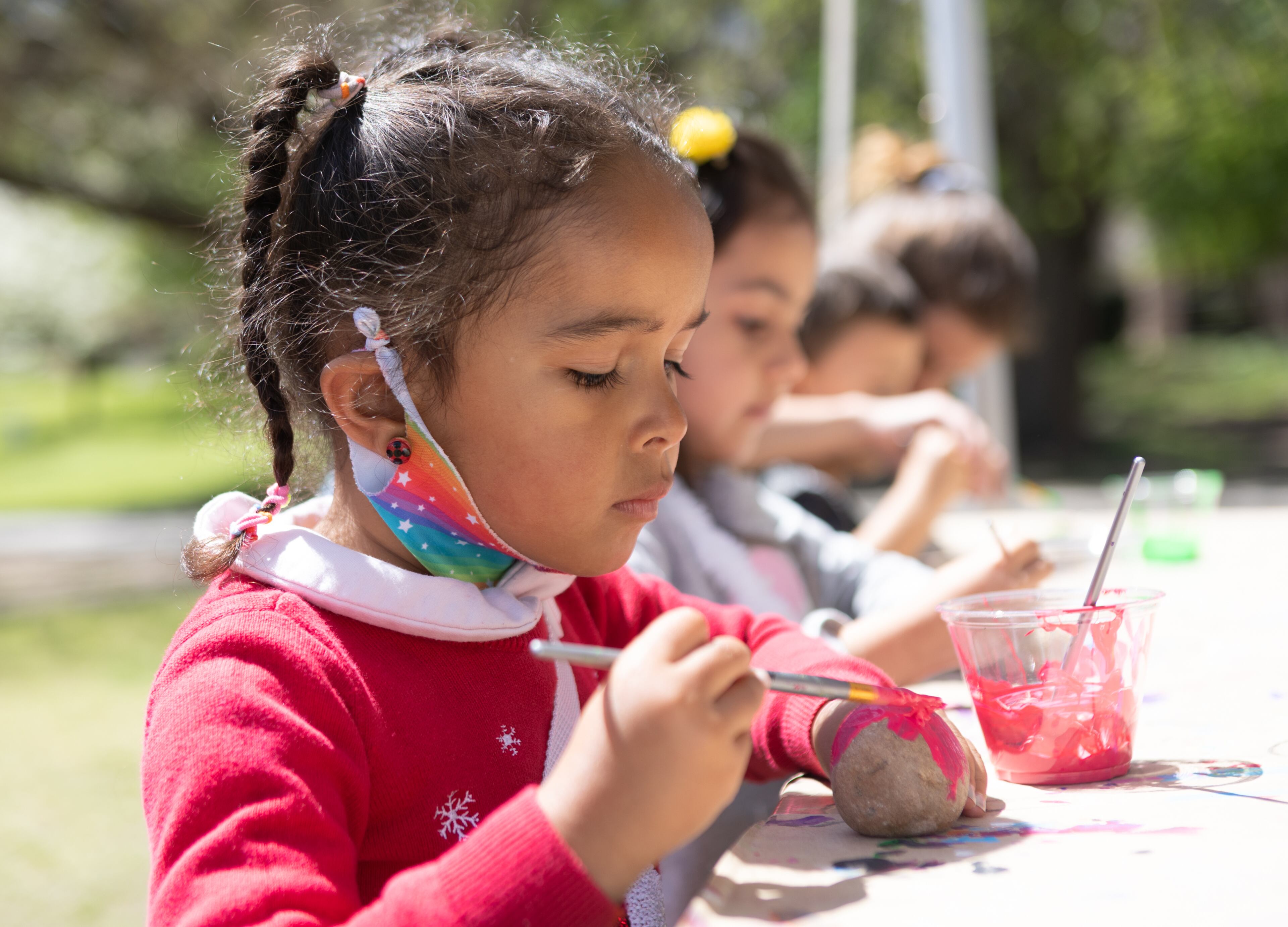 Amelia Williams, 4, is in the kids village where she paints a rock Sunday, April 10, 2022 at the 86th annual Atlanta Dogwood Festival in Piedmont Park. This year’s three-day festival had art of all shapes and sizes, jewelry, fare food and a kids village with arts and crafts, games and rides. (Jenni Girtman for The Atlanta Journal-Constitution)
