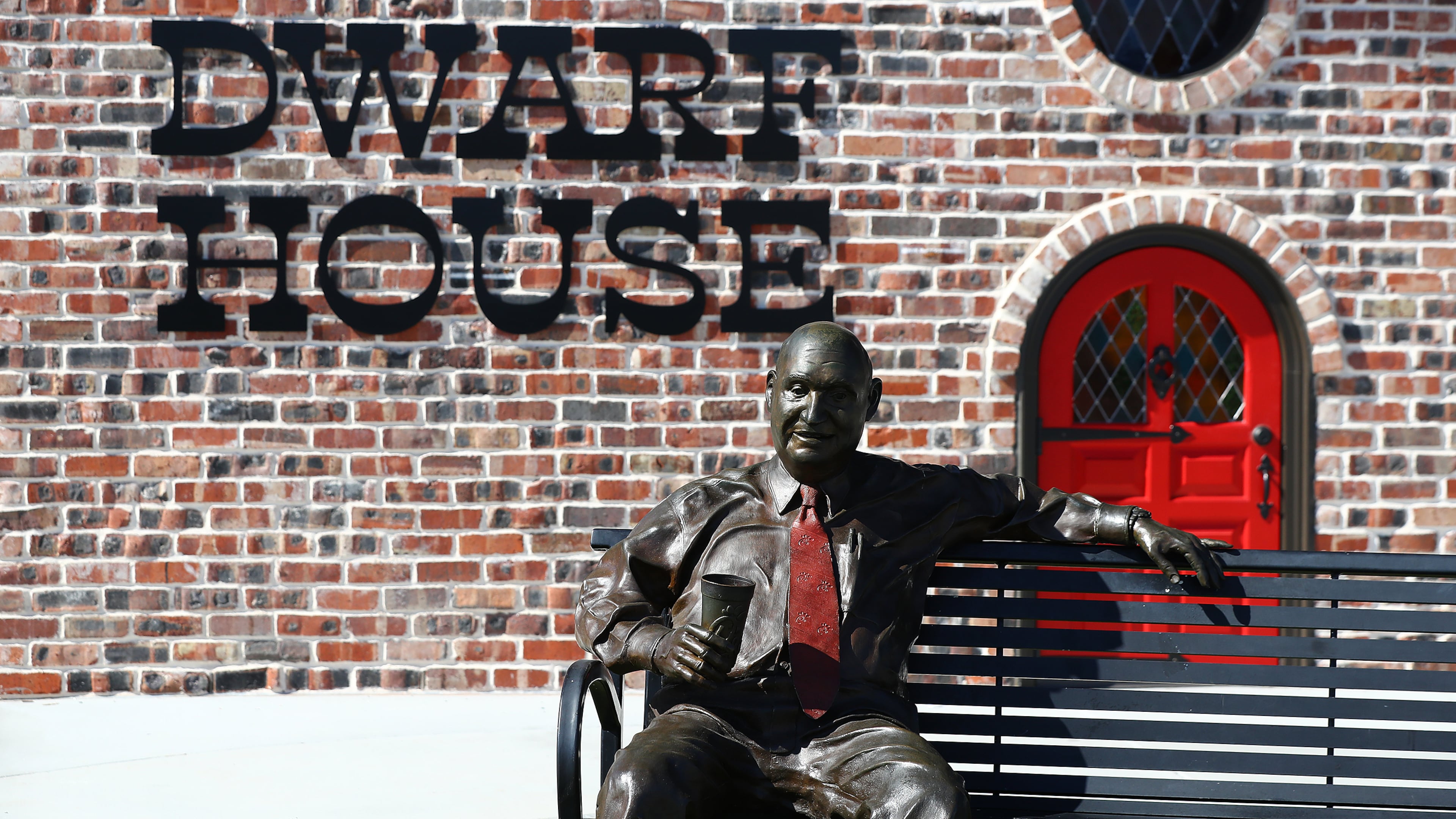 A statue of Chick-fil-A Founder S. Truett Cathy sits on a bench outside the newly renovated Dwarf House, the first of his restaurants, on Monday, Feb. 14, 2022, in Hapeville. “Curtis Compton / Curtis.Compton@ajc.com”`