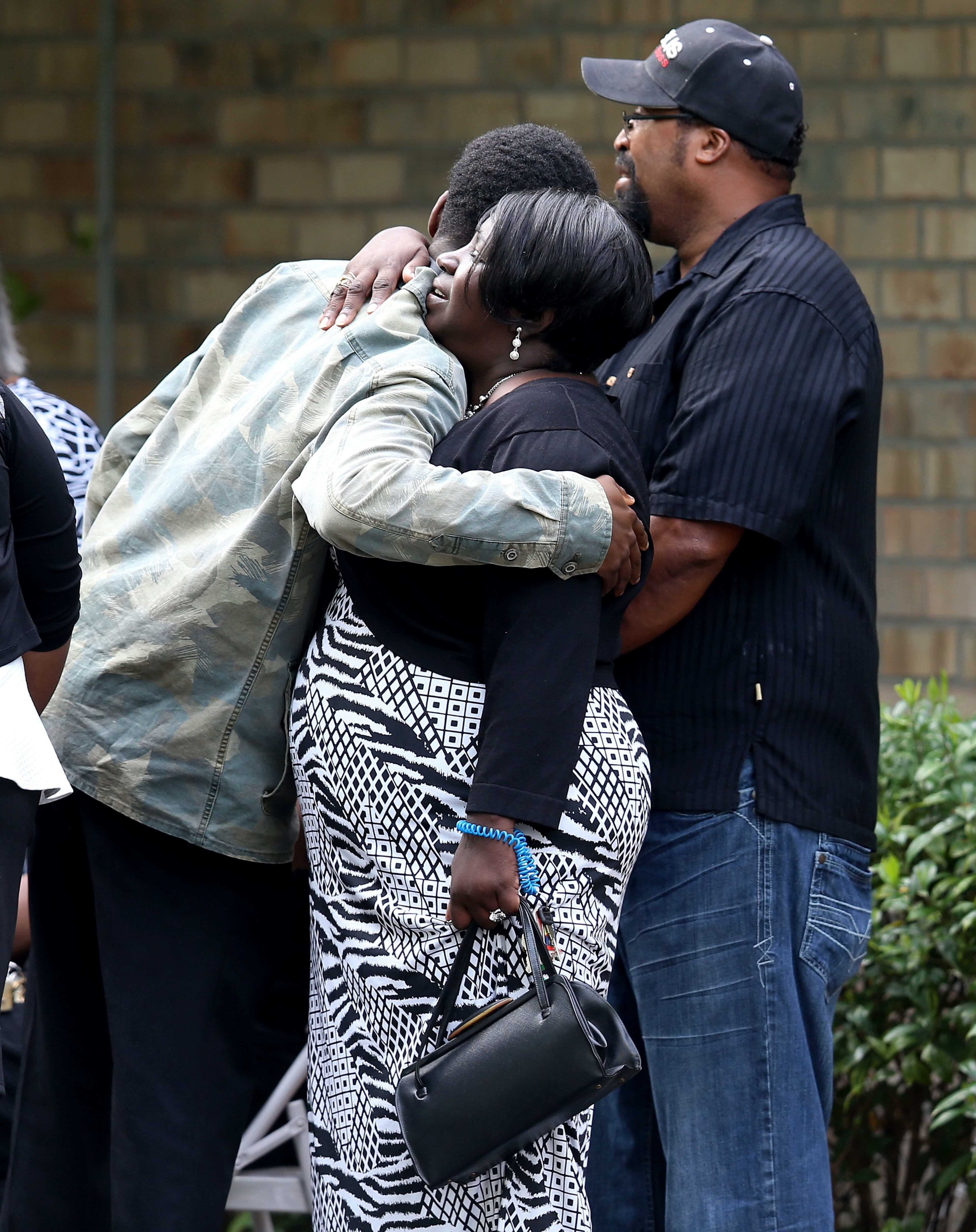 SUMMERVILLE, SC - APRIL 11: Mourners hug as they wait to enter the W.O.R.D. Ministries Christian Center for the funeral of Walter Scott, after he was fatally shot by a North Charleston police officer after fleeing a traffic stop in North Charleston on April 11, 2015 in Summerville, South Carolina. Mr. Scott was killed on April 4 by North Charleston police officer Michael T. Slager after a traffic stop. The officer now faces murder charges. (Photo by Joe Raedle/Getty Images)