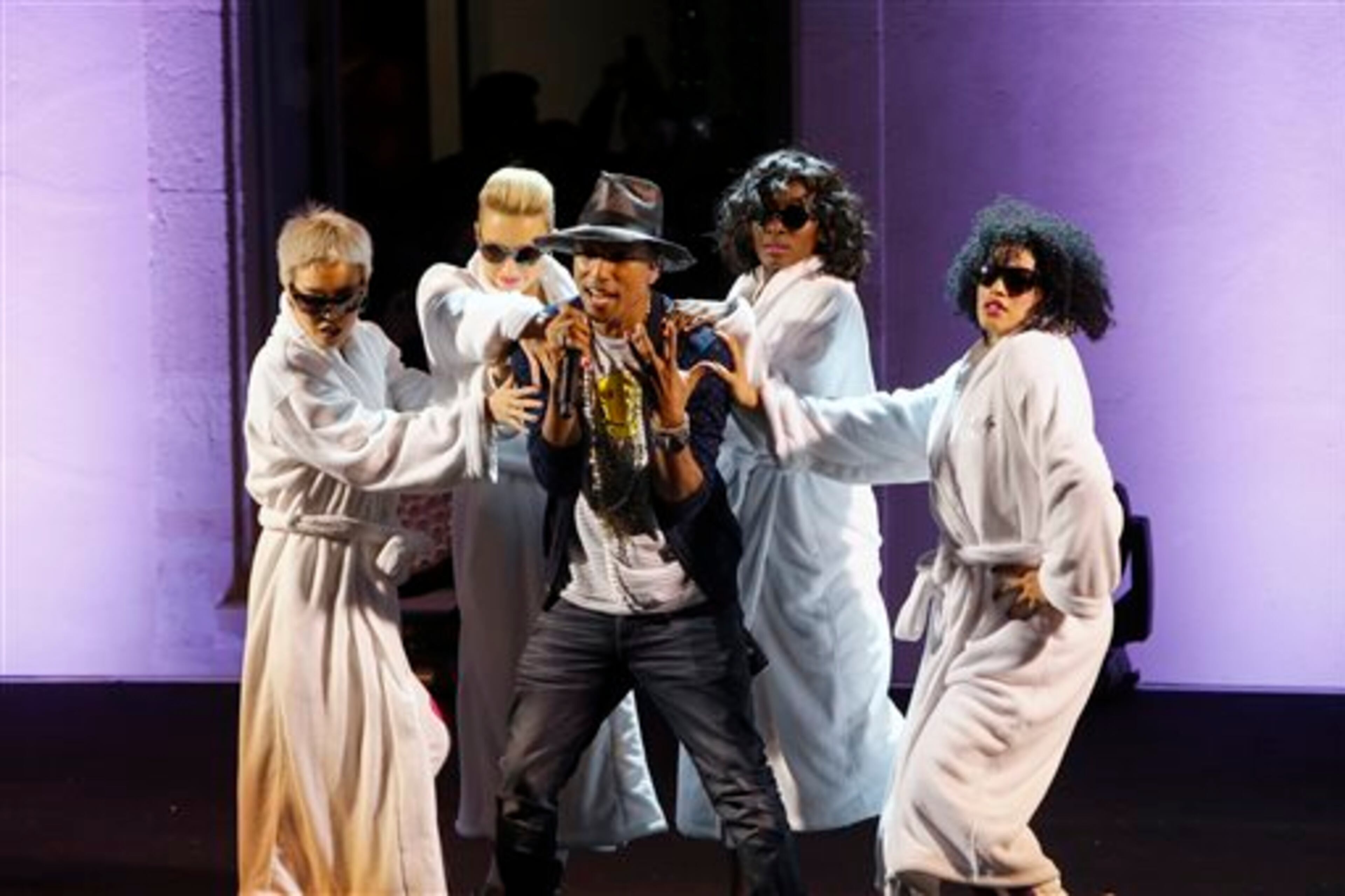 Singer Pharrell Williams performs on stage during a private concert for the exhibition "GIRL" at the Perrotin Gallery in Paris, Monday, May 26, 2014. Williams curated an exhibition encompassing around 40 art pieces, presenting their visions of femininity, muses, female creativity and freedom. The show opens on May 27 and runs through June 27. (AP Photo/Francois Mori)