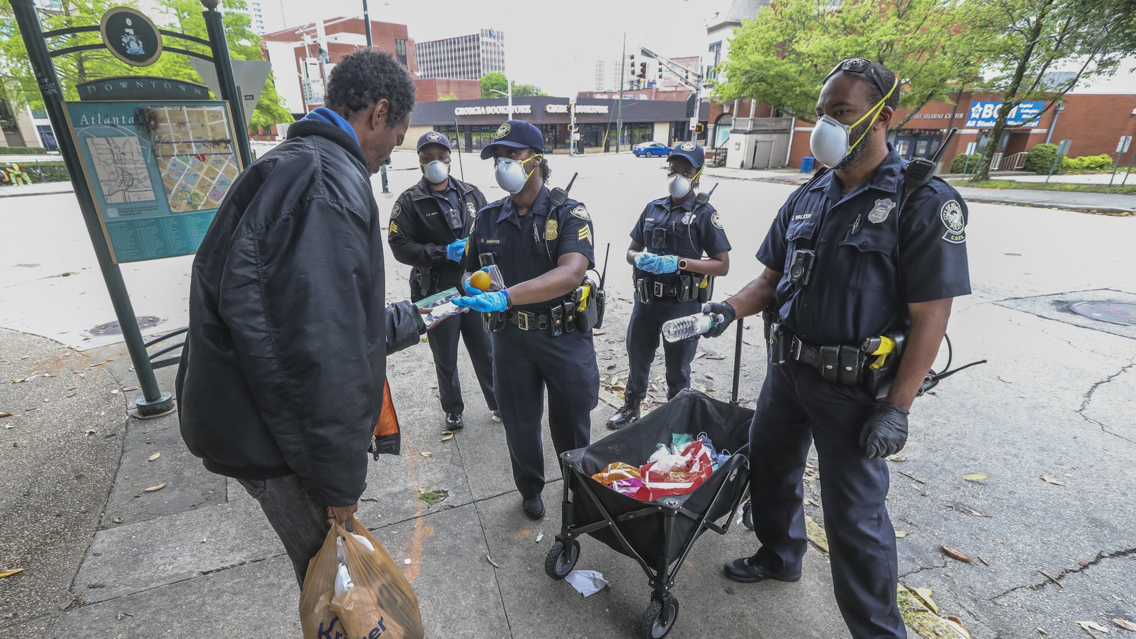 Atlanta Police Department officers distribute masks to the homeless at Hurt Park downtown on Friday, April 24, 2020. JOHN SPINK/JSPINK@AJC.COM