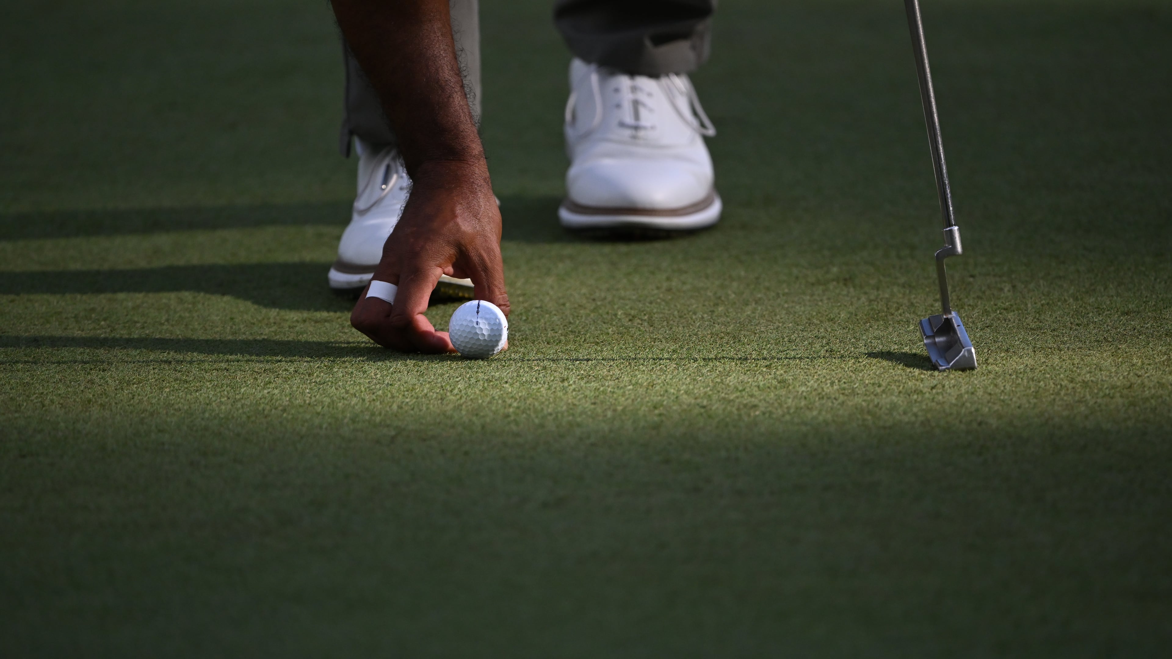 Tiger Woods places his Bridgestone ball on the sixth green at the 2024 Masters. Bridgestone Golf made golf balls under its own brand and others, but will be closing in June. (Hyosub Shin/AJC 2024)