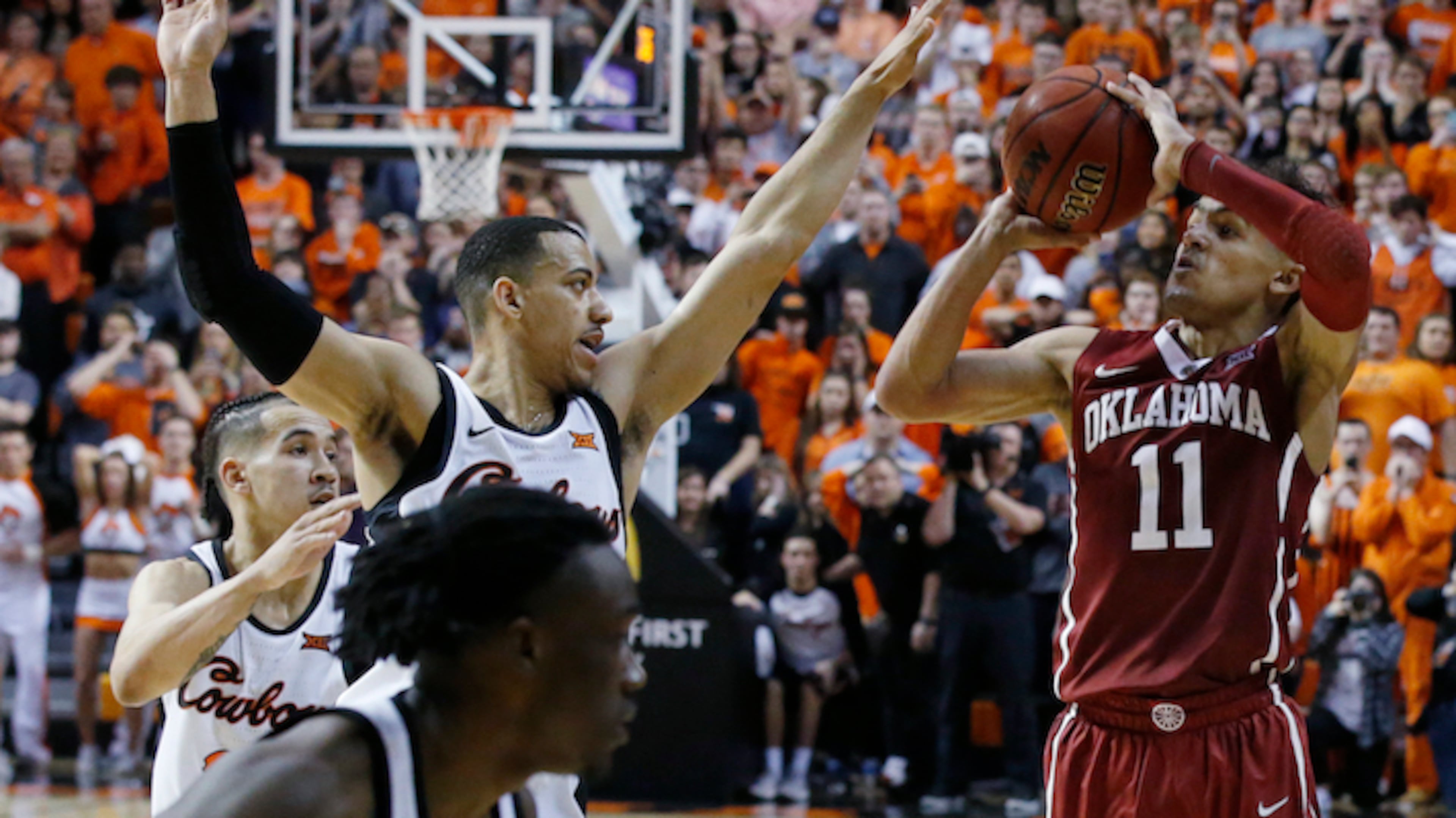 Oklahoma guard Trae Young (11) takes the final shot of overtime in front of Oklahoma State guard Kendall Smith, left, in an NCAA college basketball game against in Stillwater, Okla., Saturday, Jan. 20, 2018. Oklahoma State won 83-81 in overtime. (AP Photo/Sue Ogrocki)