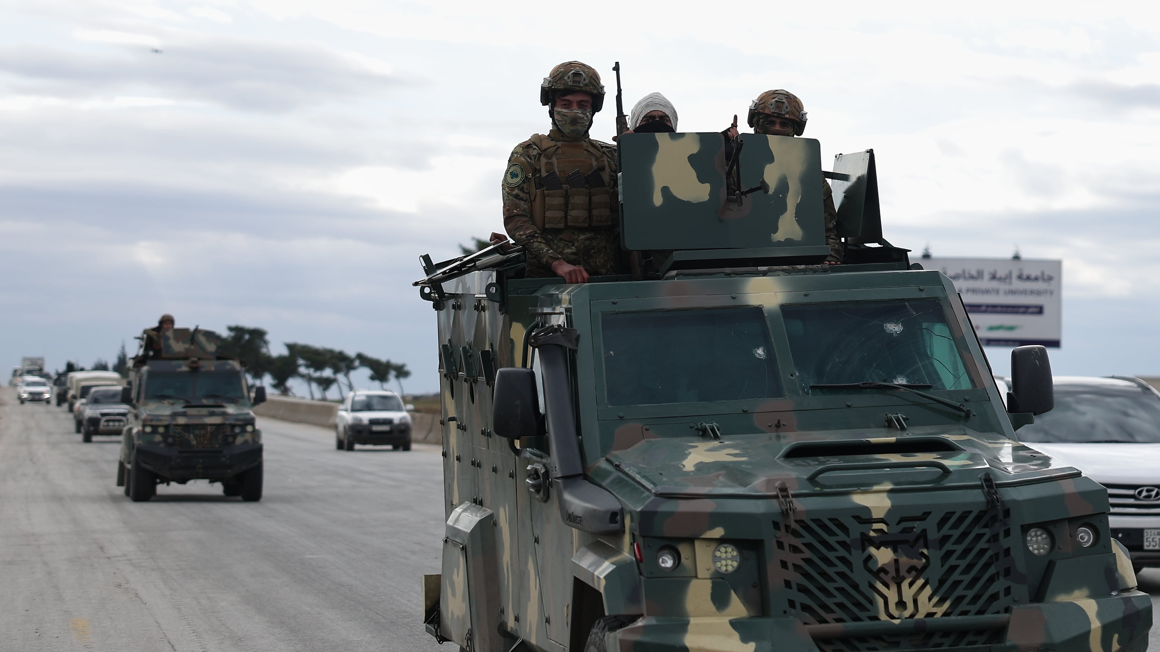 Syrian government soldiers stand on their armoured vehicle, as their convoy passes on a highway to the Deir Hafer village for a possible escalation fighting with the Kurdish fighters, in eastern Aleppo, Syrian, Wednesday, Jan. 14, 2026. (AP Photo/Ghaith Alsayed)