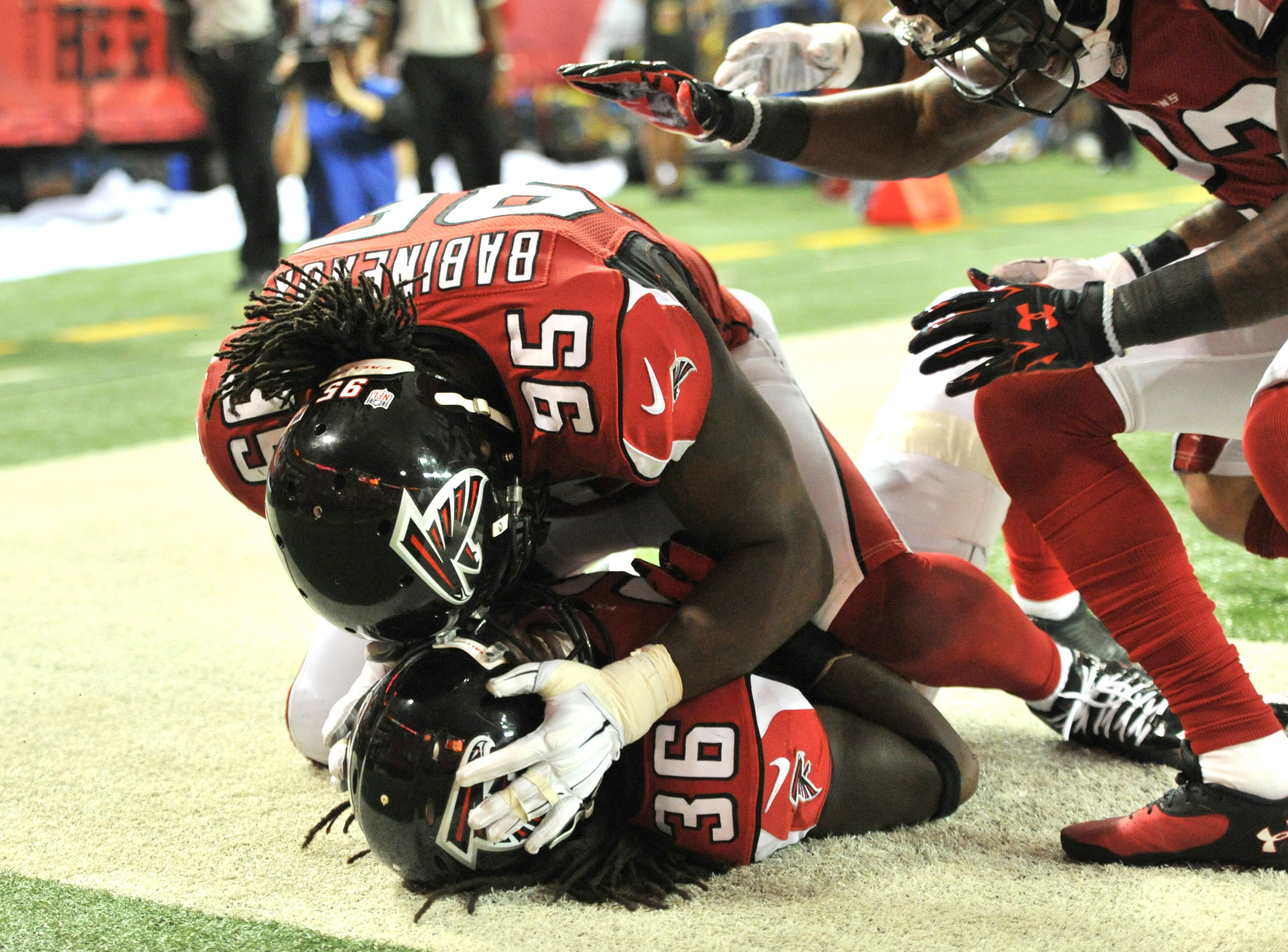Atlanta Falcons defensive back Kemal Ishmael (36) is celebrated by Atlanta Falcons defensive end Jonathan Babineaux (95) for his touchdown against the Tampa Bay Buccaneers in the first half during the first half in their NFL football game on Thursday, September 18, 2014. HYOSUB SHIN / HSHIN@AJC.COM