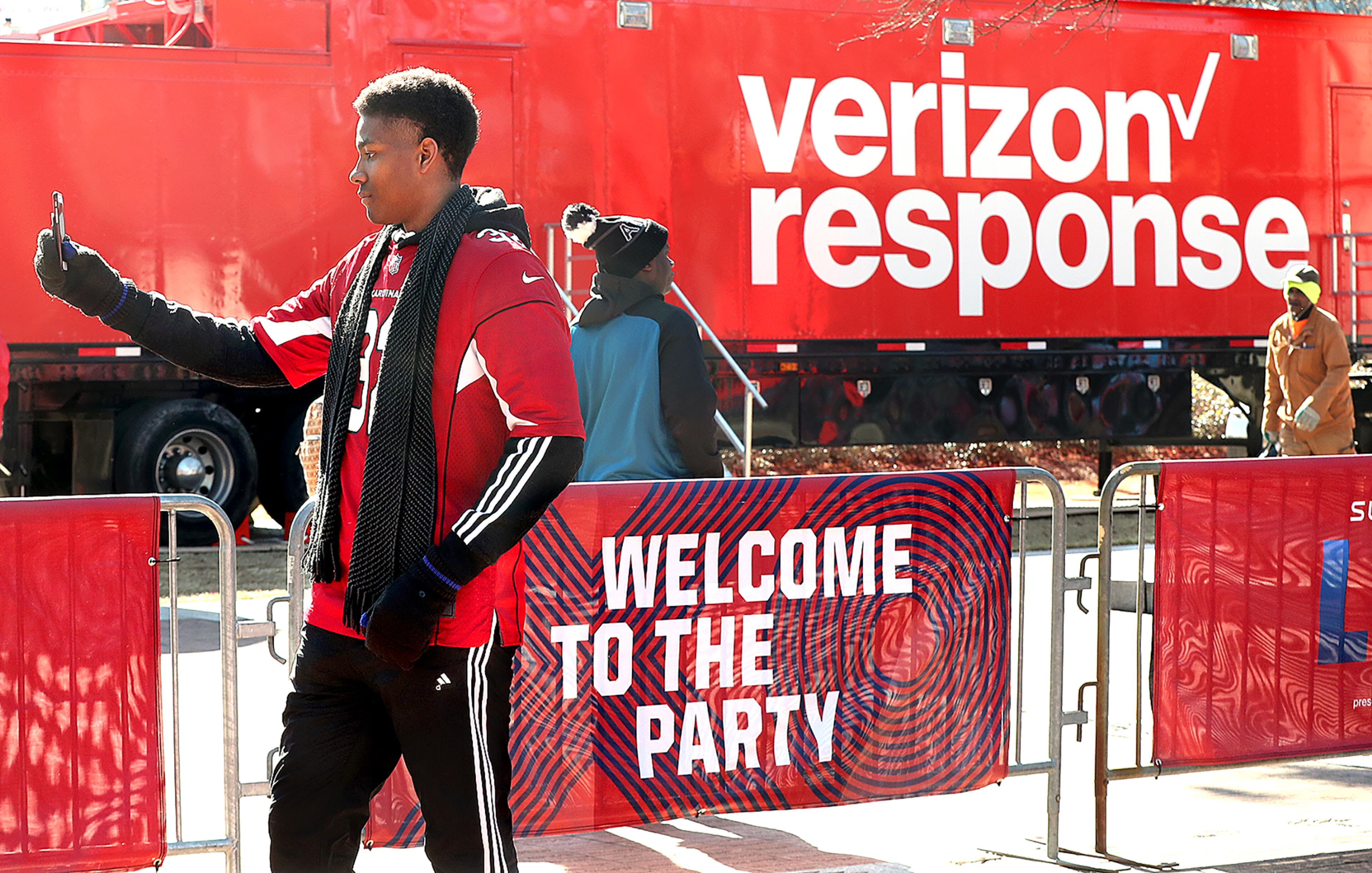 Jan. 31, 2019 Atlanta: Merrion Mitchner, Buford, snaps a photo on his cell phone outside Super Bowl Live at Centennial Olympic Park beside a Verizon response tractor trailer truck on Thursday, Jan. 31, 2019, in Atlanta. The crunch of Super Bowl fans flooding into downtown Atlanta is prompting wireless providers like Verizon to boost their capacity in order to keep the calls and texts moving during the big game. Curtis Compton/ccompton@ajc.com