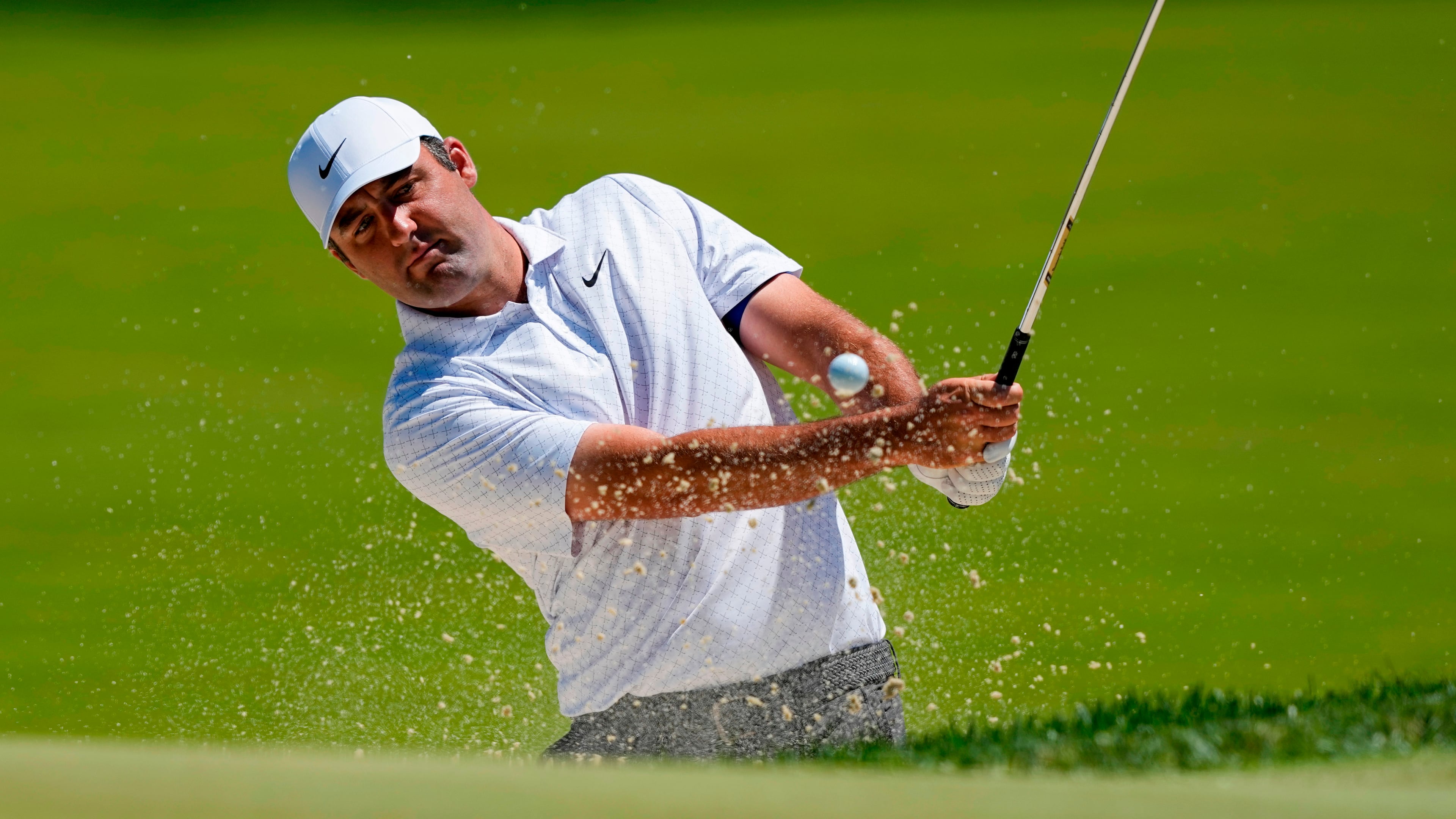 Scottie Scheffler hits from the bunker on the third green during a PGA Championship golf tournament practice round at Aronimink Golf Club, Tuesday, May 12, 2026, in Newtown Square, PA. (AP Photo/Carolyn Kaster)