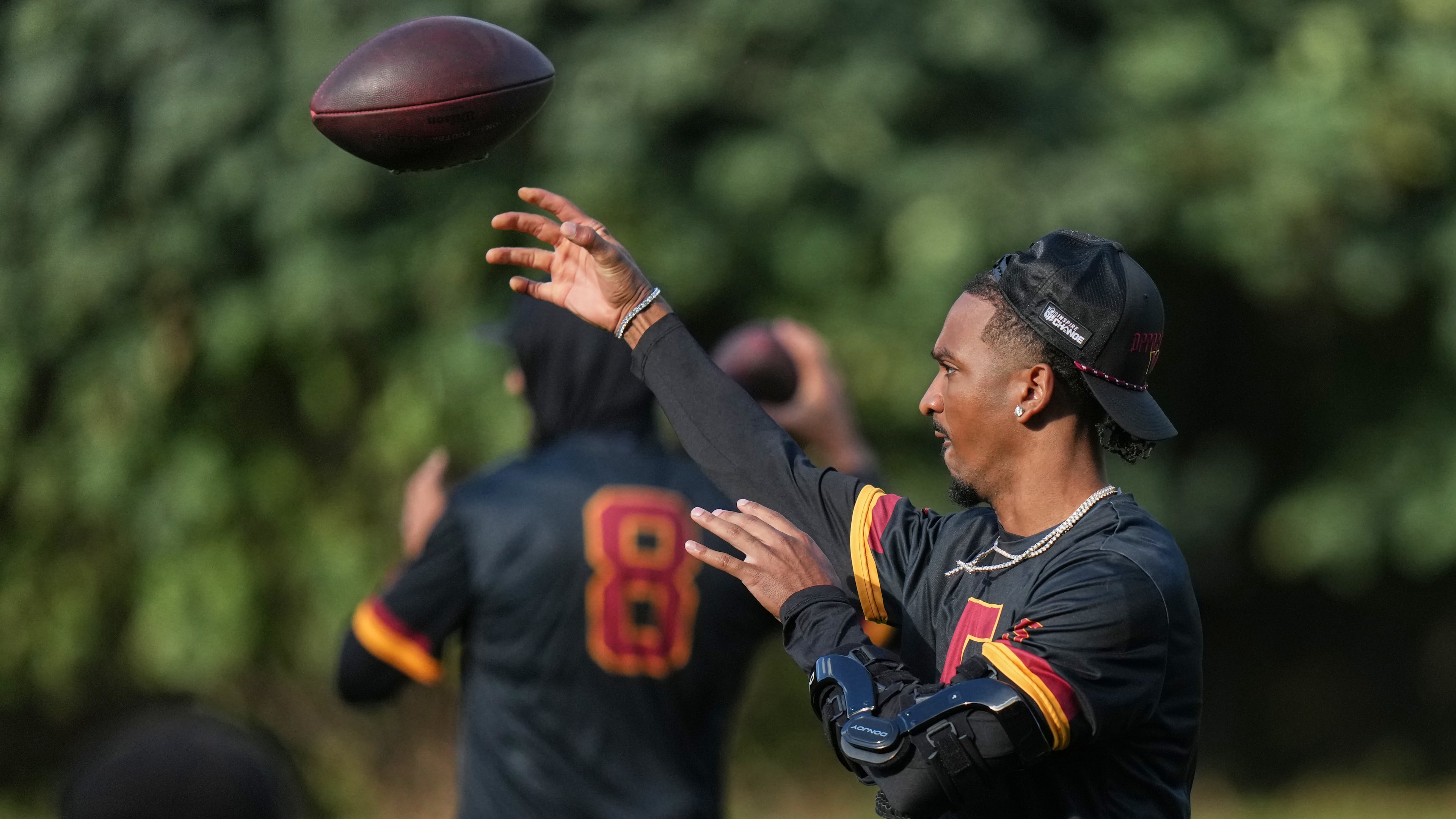 Washington Commanders quarterback Jayden Daniels (5), throws a pass during a NFL Football practice session in London, Wednesday, Sept. 30, 2026. (AP Photo/Alastair Grant)