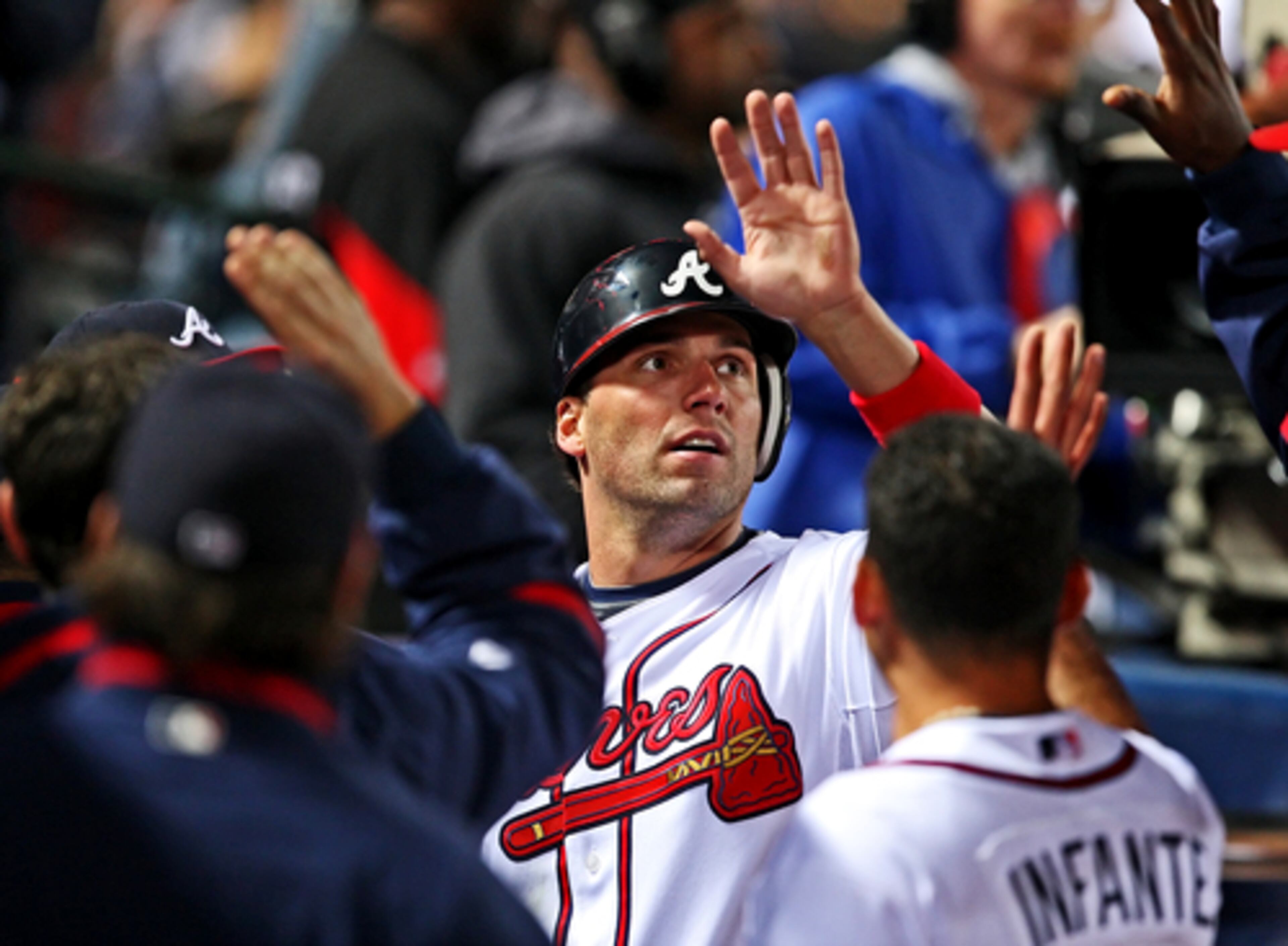 Jeff Francouer of the Braves high fives teammates in the dugout after scoring the tying run in the sixth inning.