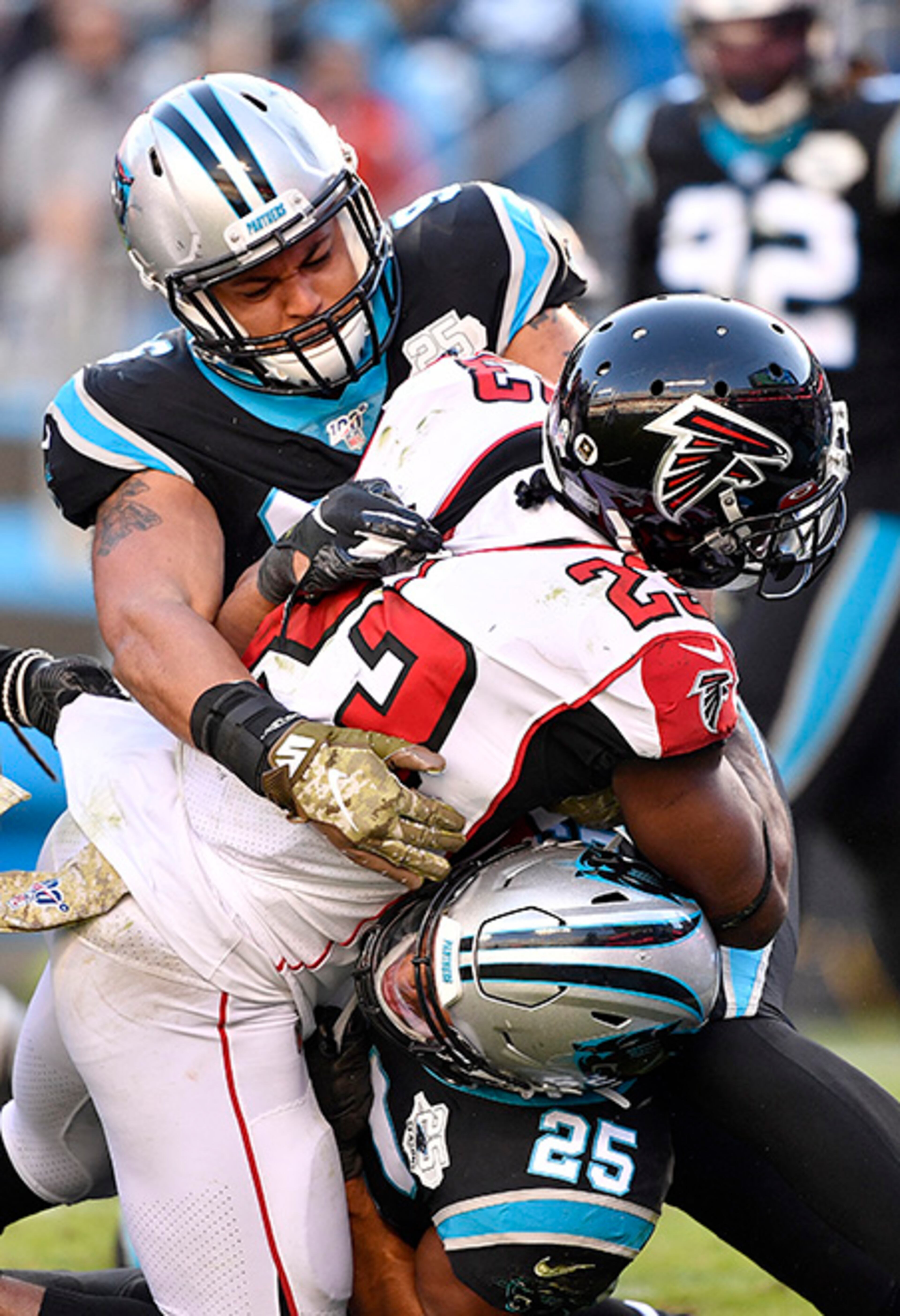 Carolina's Wes Horton (96) and Eric Reid (25) stop Falcons running back Brian Hill during the third quarter Sunday, Nov. 17. 2019, at Bank of America Stadium in Charlotte.