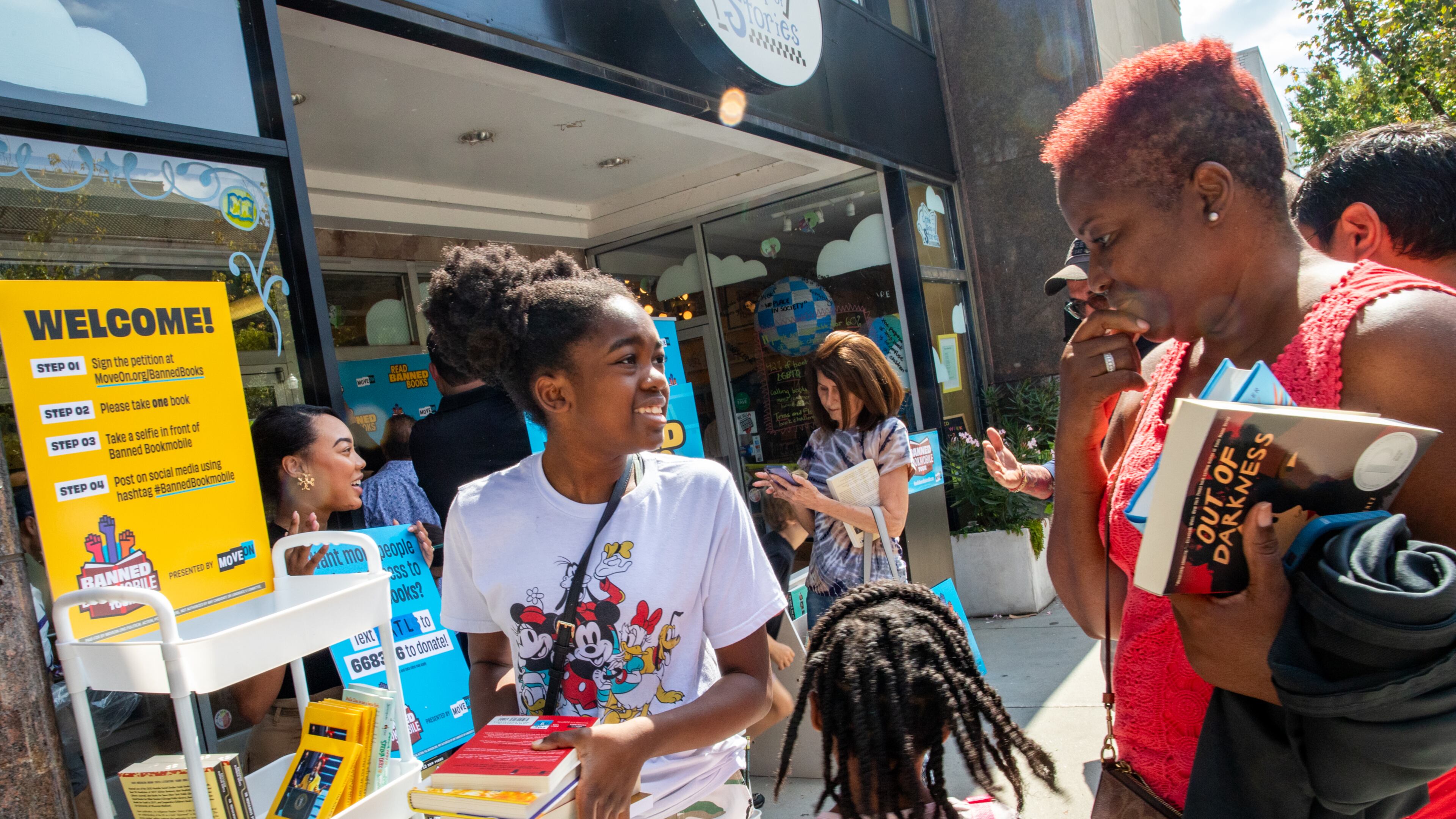 MoveOn Political Action's Banned Bookmobile distributed free banned books at the kickoff of National Banned Book Week in Decatur, where Kimora Bernard (from left), 12, her sister, Kimiyah, 5, and grandmother Carmen Bernard (right) of Stone Mountain pick out a few of the banned books that cannot be checked out at some public school libraries on Sunday, Oct. 1, 2023, at Little Shop of Stories in the Decatur Square. (Jenni Girtman for The Atlanta Journal-Constitution.)