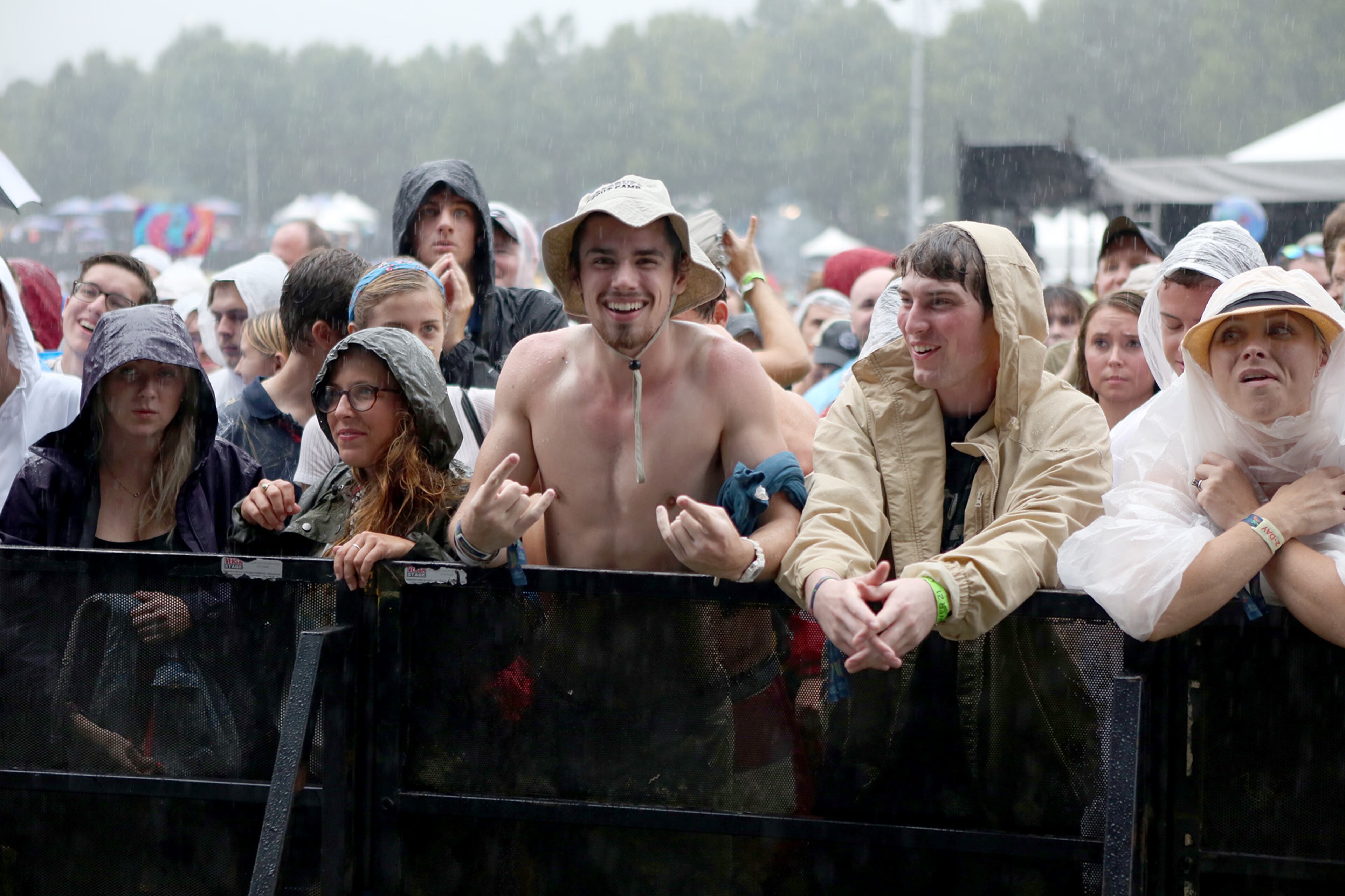 Fans of Nathaniel Rateliff wait in the pouring rain for him to take the state at Music Midtown Sunday. The event was temporarily evacuated due to the threat of lightning. (Akili-Casundria Ramsess/Special to the AJC)