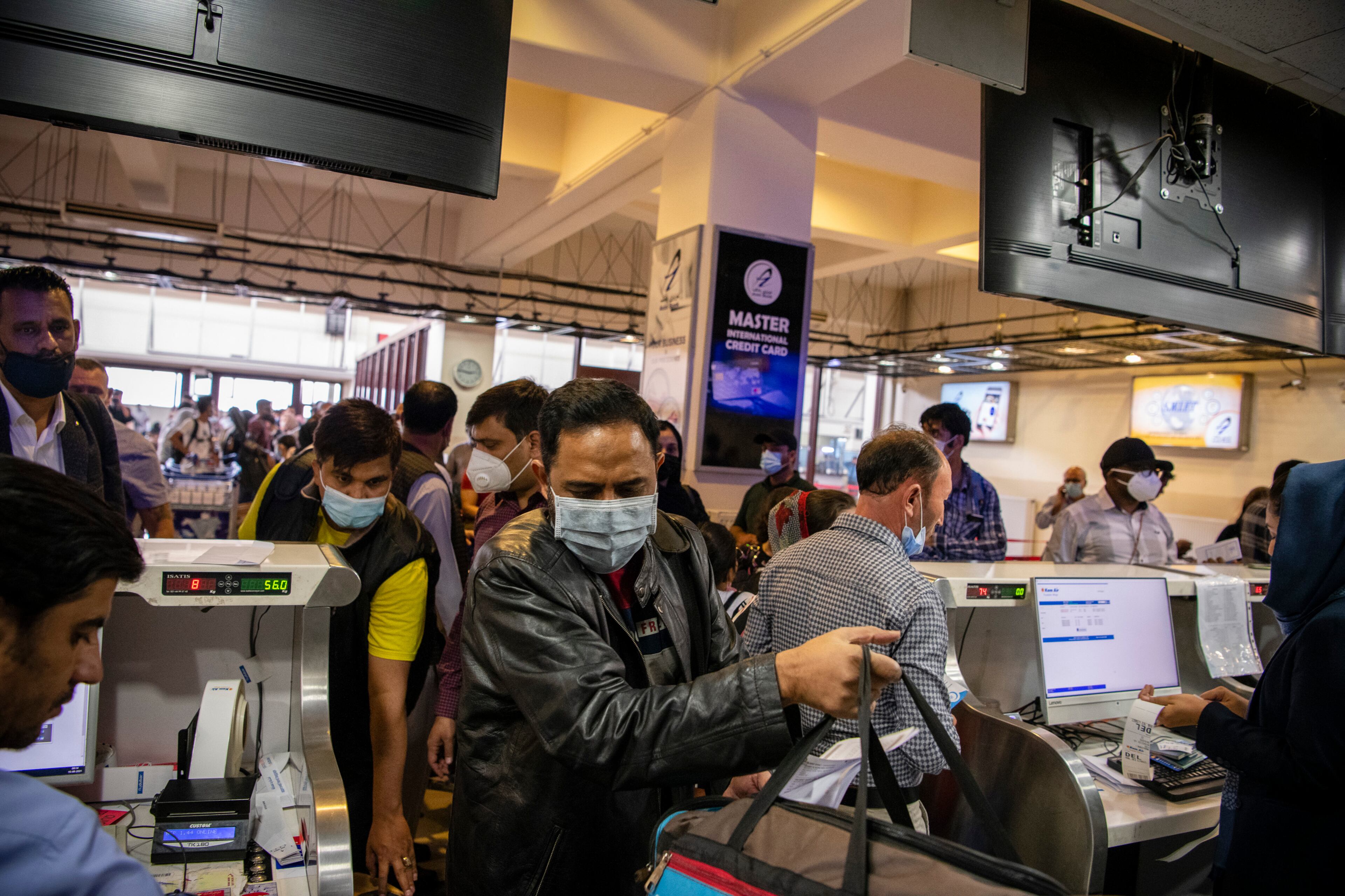 Afghans and travelers pass through checkpoints at the Hamid Karzai International Airport in Kabul, Afghanistan ahead of the Taliban’s arrival, Aug. 15, 2021. (Jim Huylebroek/The New York Times)