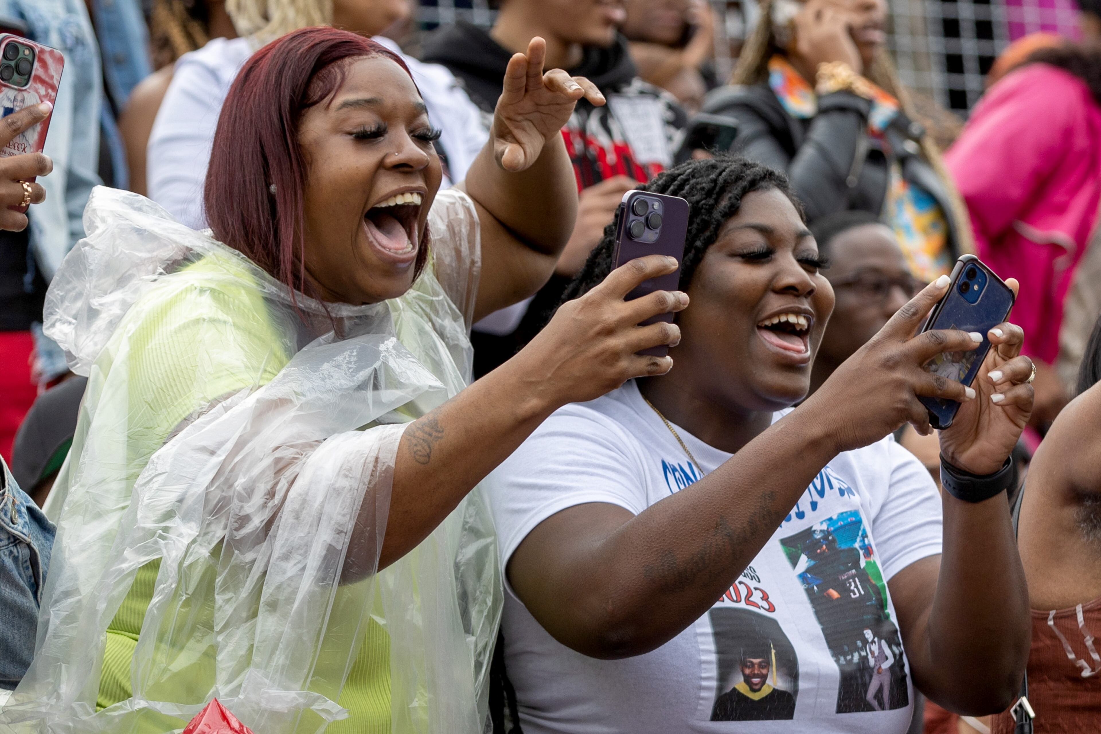 People try to get the attention of their friends and family as graduates walk into Panther Stadium for the start of Clark Atlanta University's commencement ceremony Saturday, May 20, 2023. (Steve Schaefer /steve.schaefer@ajc.com)