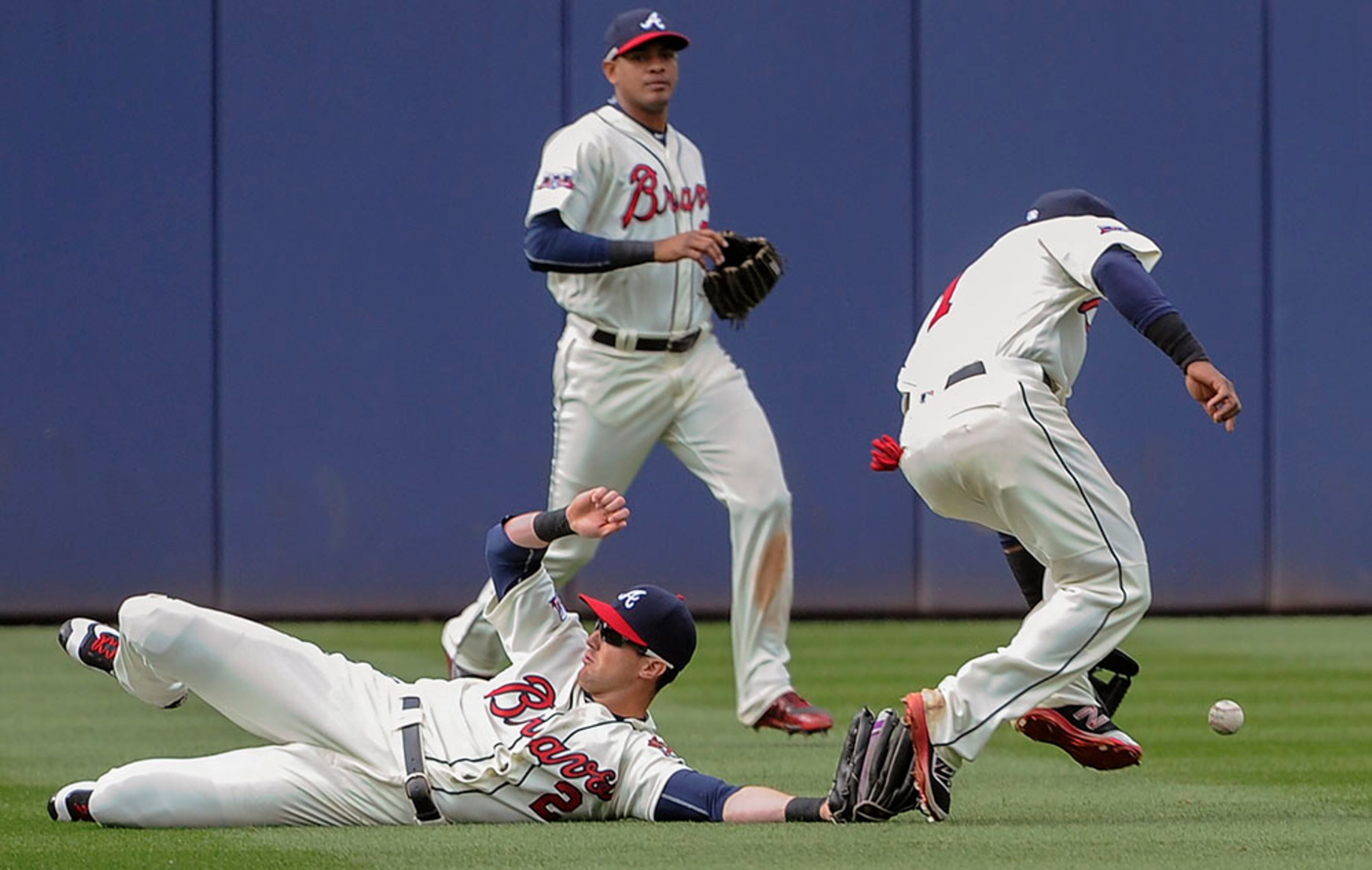 Atlanta Braves center fielder Drew Stubbs, slides as shortstop Erick Aybar (right) reaches for the center field fly ball of St. Louis Cardinals' Matt Holliday who singles during the eighth inning Sunday, April 10, 2016, in Atlanta.