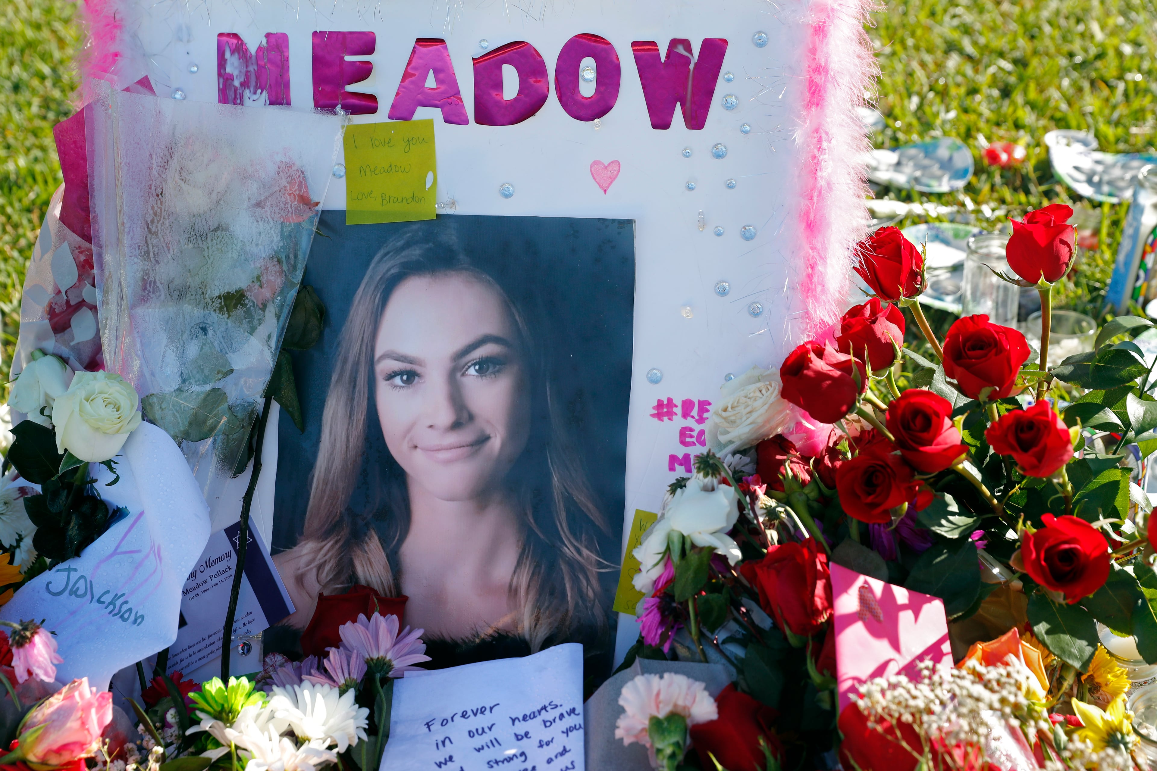 A photo of Meadow Pollack, one of the seventeen victims who was killed in the Wednesday shooting at Marjory Stoneman Douglas High School, sits against a cross as part of a public memorial, in Parkland, Fla., Saturday, Feb. 17, 2018. Nikolas Cruz, a former student, was charged with 17 counts of premeditated murder on Thursday. (AP Photo/Gerald Herbert)